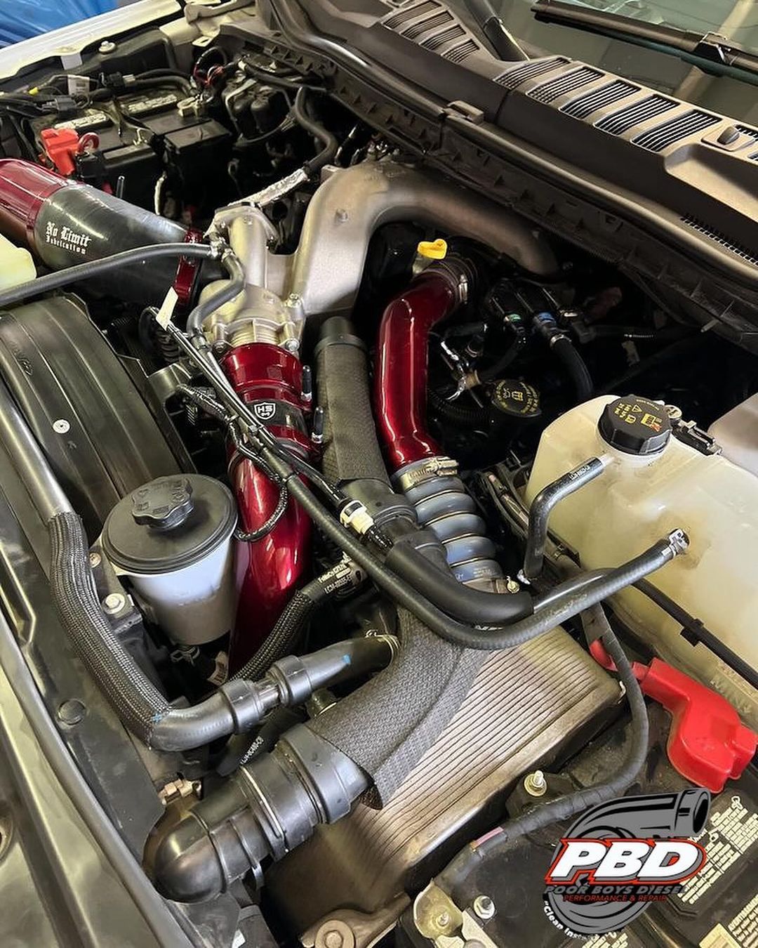 A close up of the engine of a truck with the hood open.