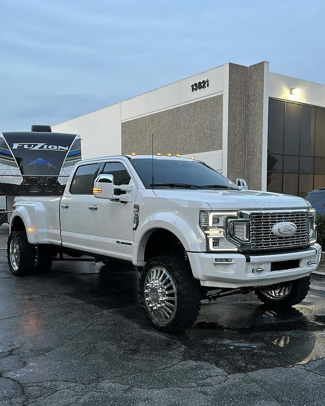 A white truck is parked in front of a building.