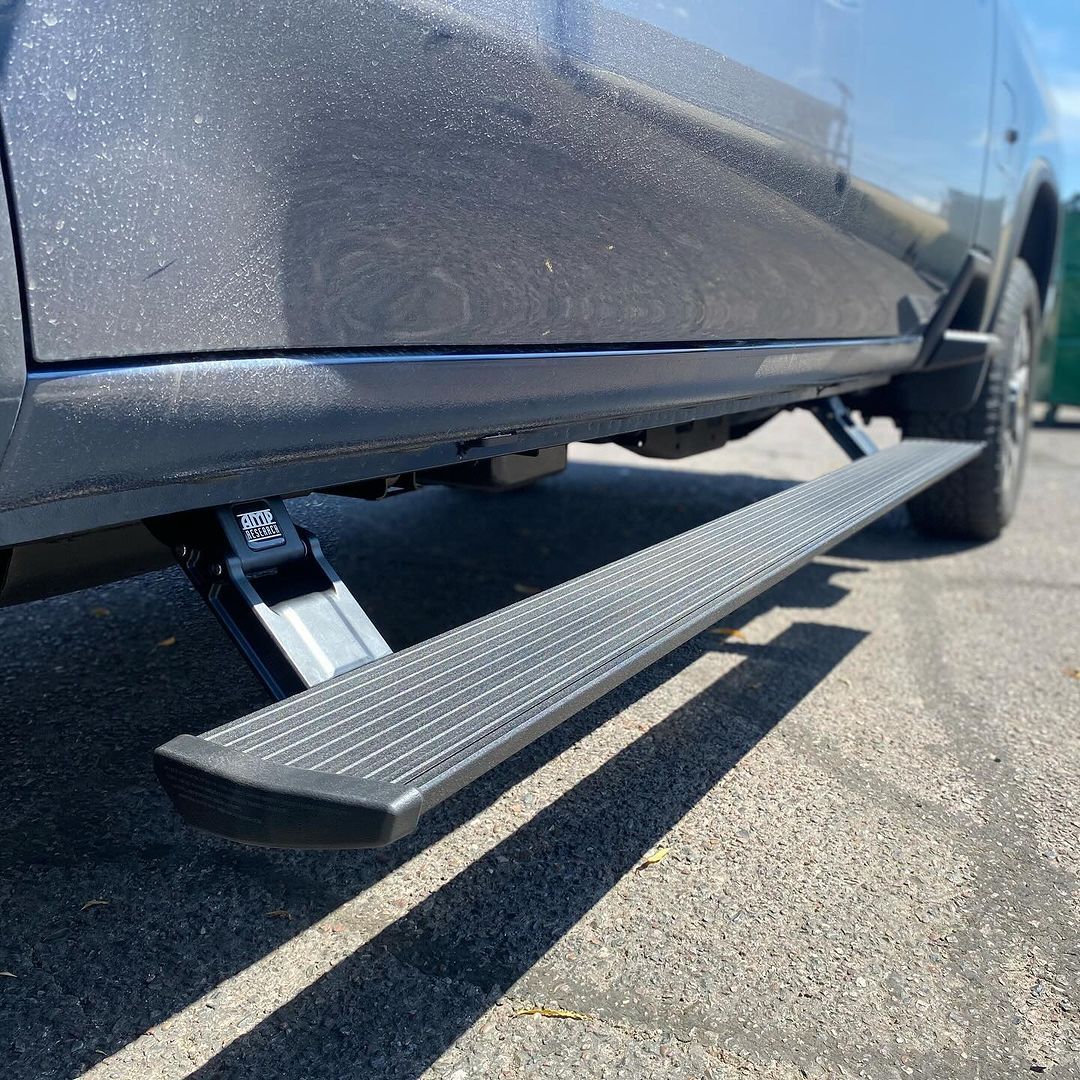 A car with a side step is parked on the side of the road.