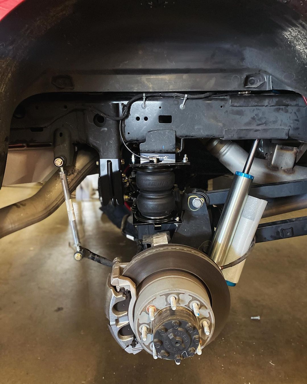 A close up of a car 's suspension and brake system.