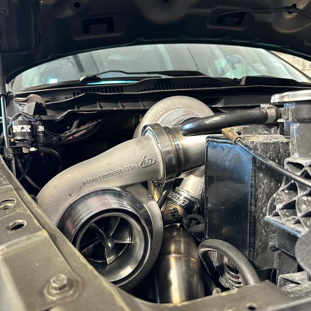 A close up of a car engine with the hood open.