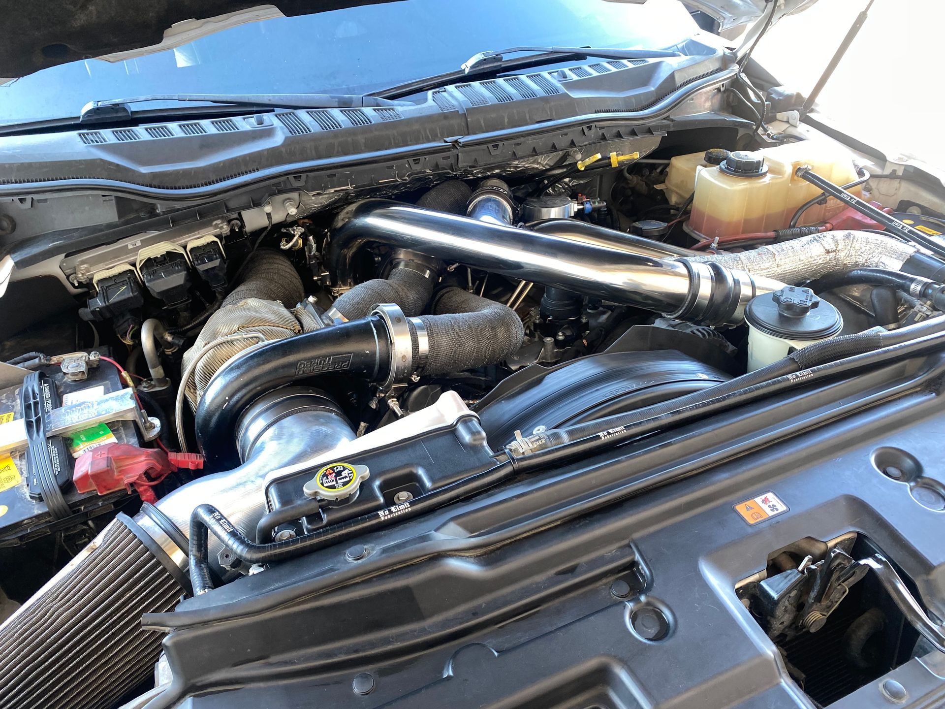 A close up of a car engine with the hood open.