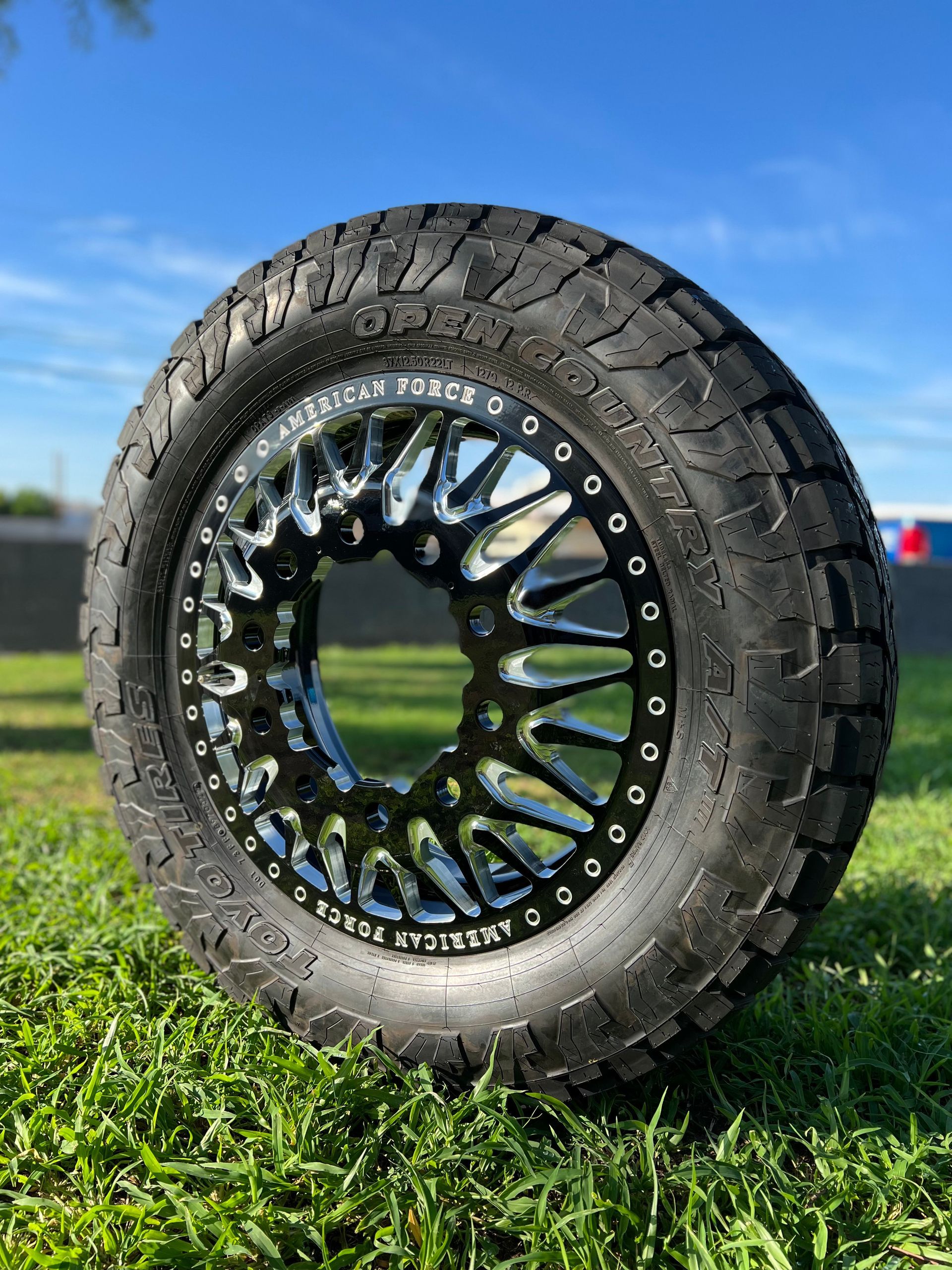 A tire is sitting on top of a lush green field.