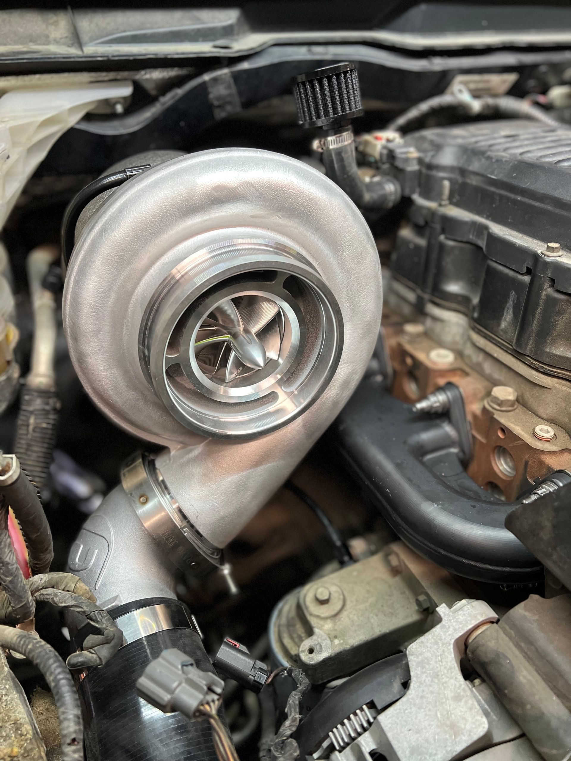 A turbocharger is sitting inside of a car engine.