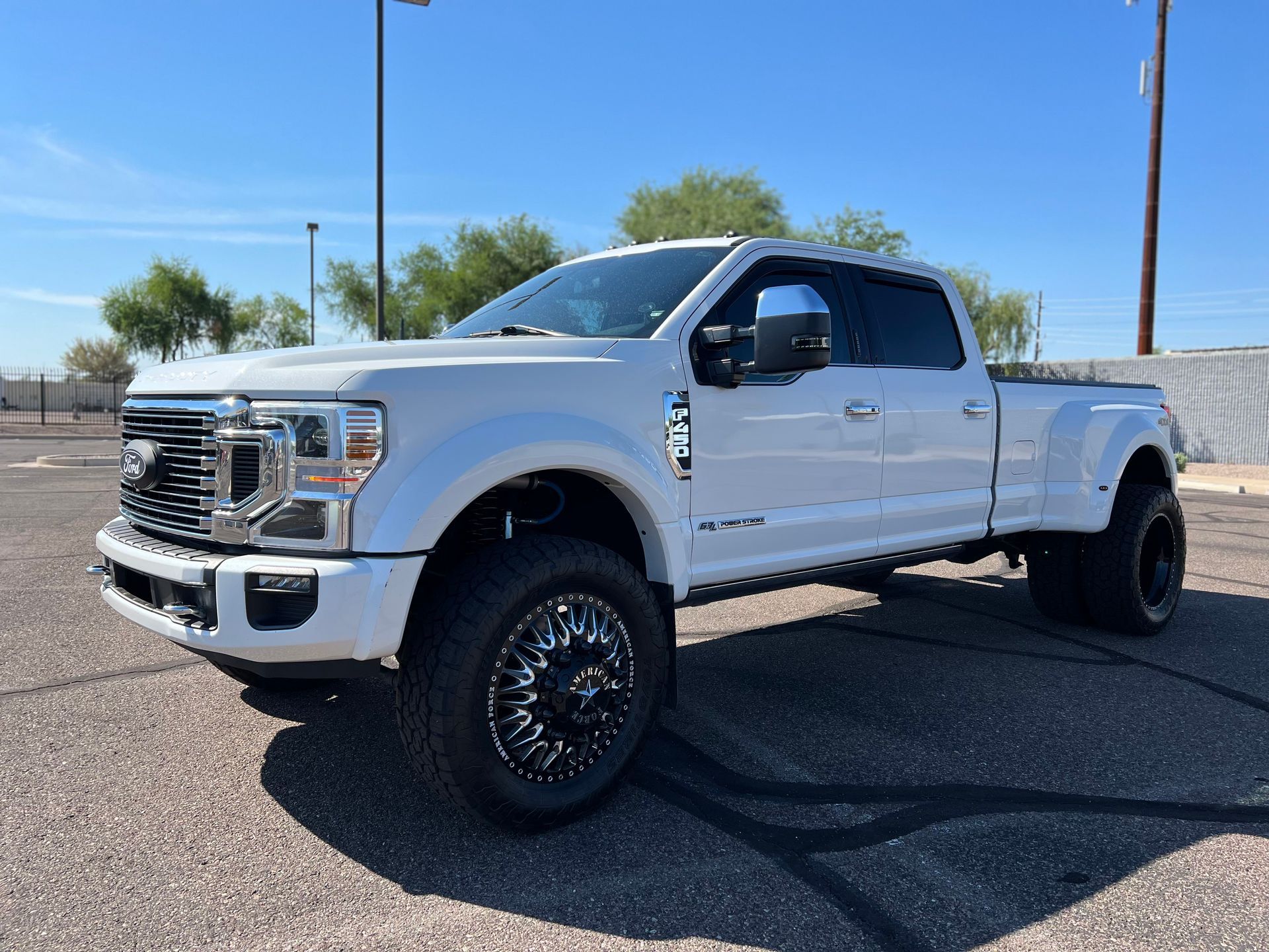 A white ford truck is parked in a parking lot.