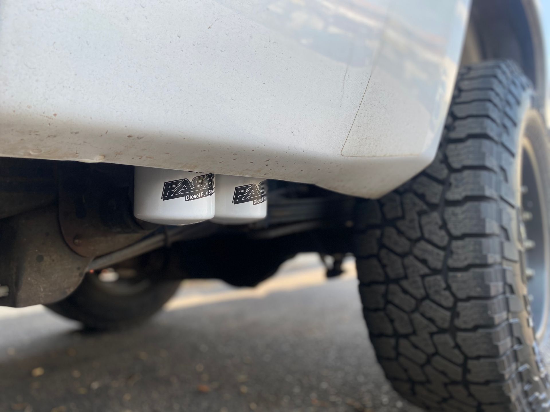 A close up of a white truck with a black tire