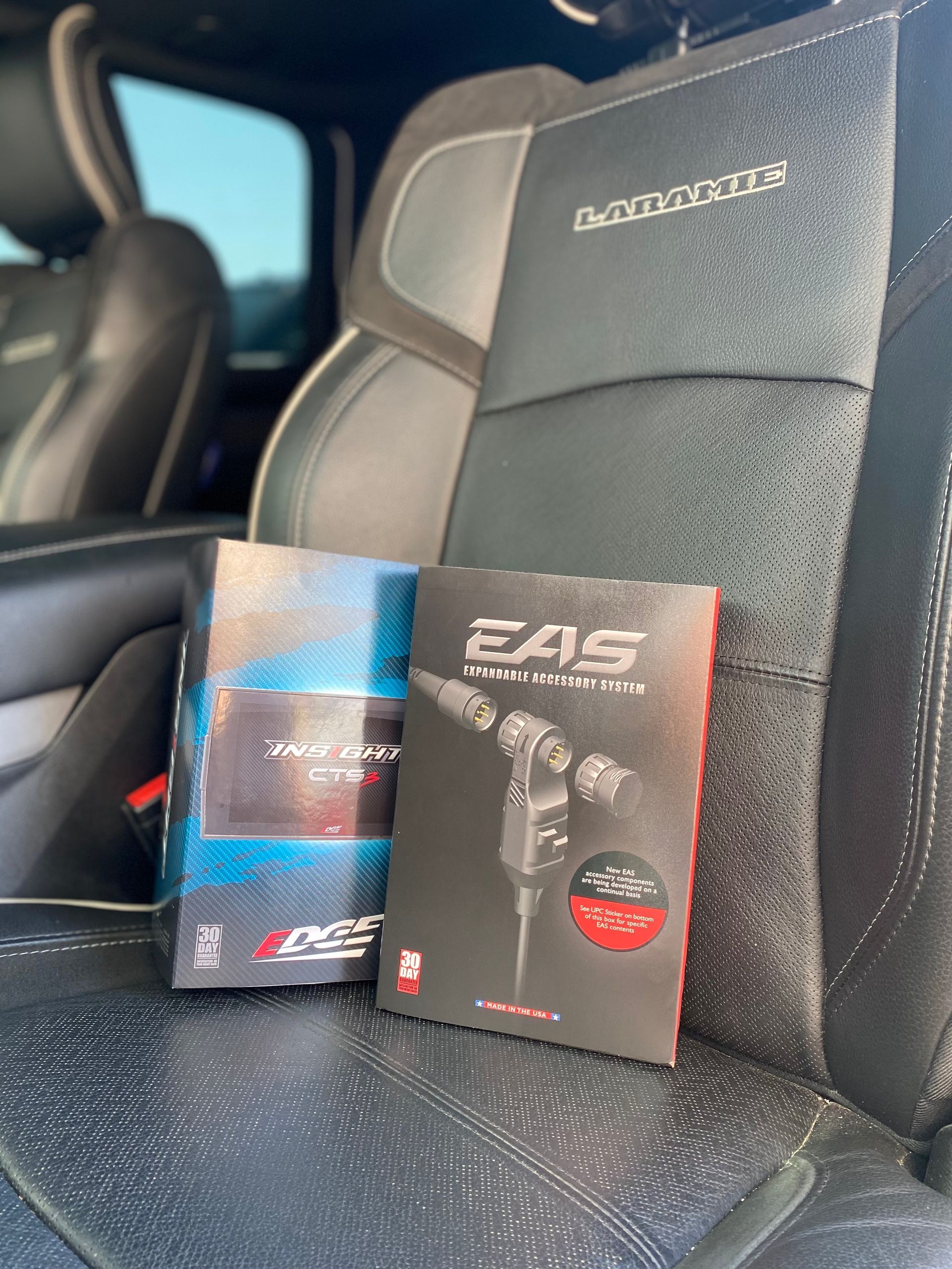 Two boxes of eas products are sitting on the back seat of a car.