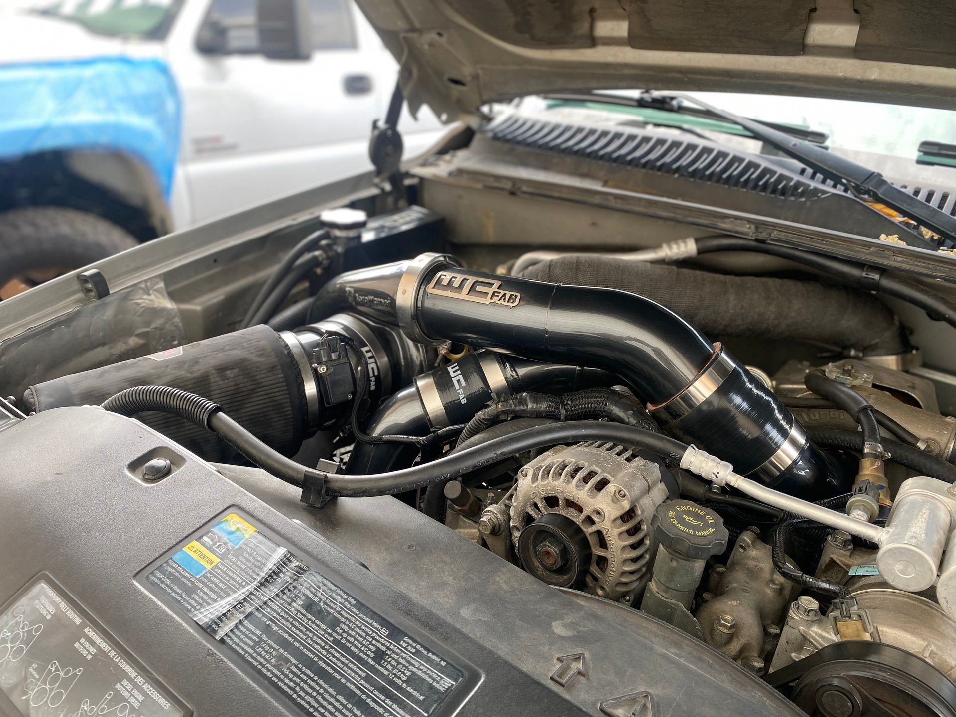 A close up of a car engine with the hood open.