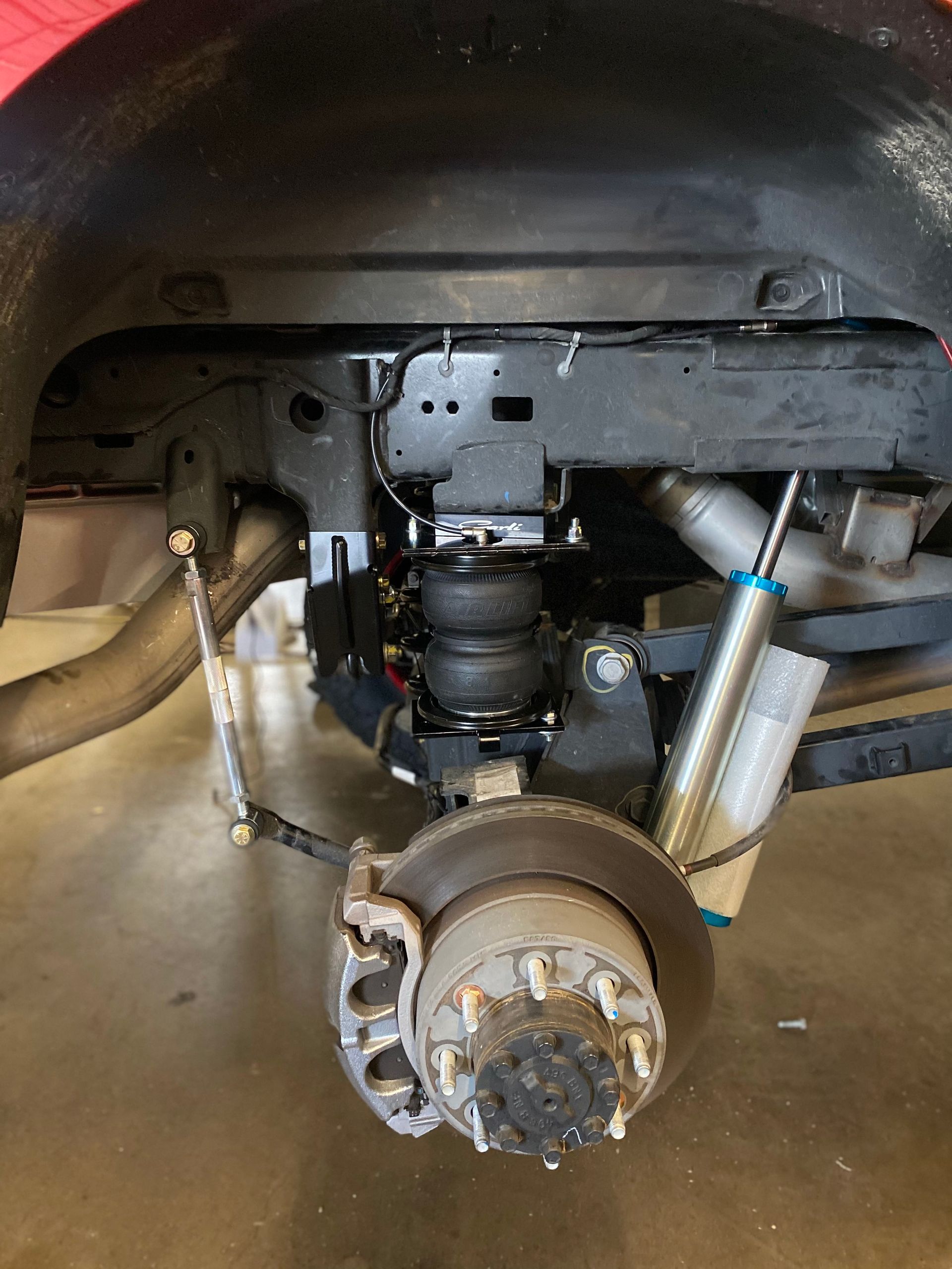 A close up of the underside of a truck 's suspension system.