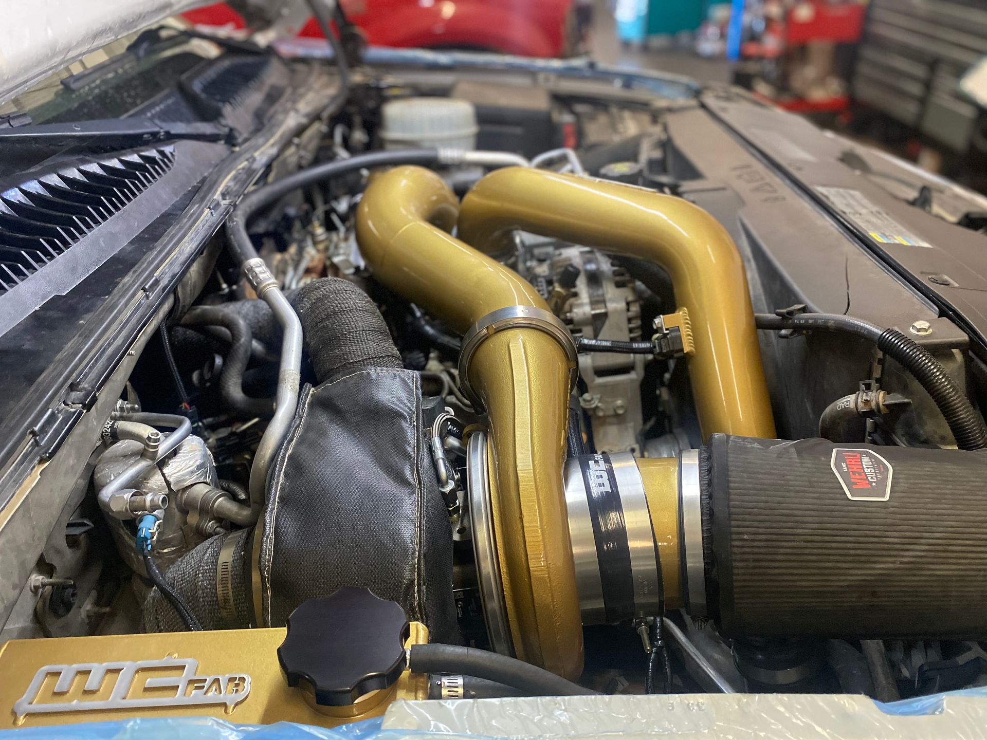 A close up of a car engine with a hood open