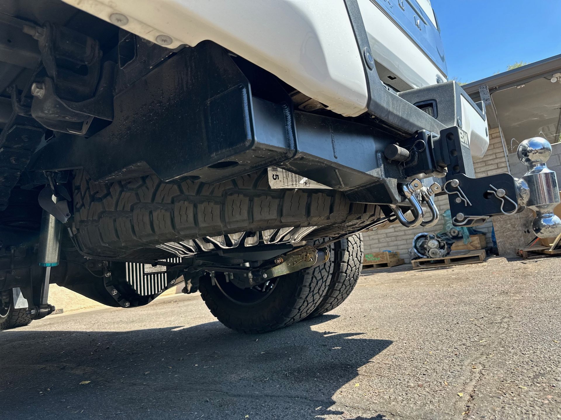 A white truck with a trailer attached to it is parked in a parking lot.