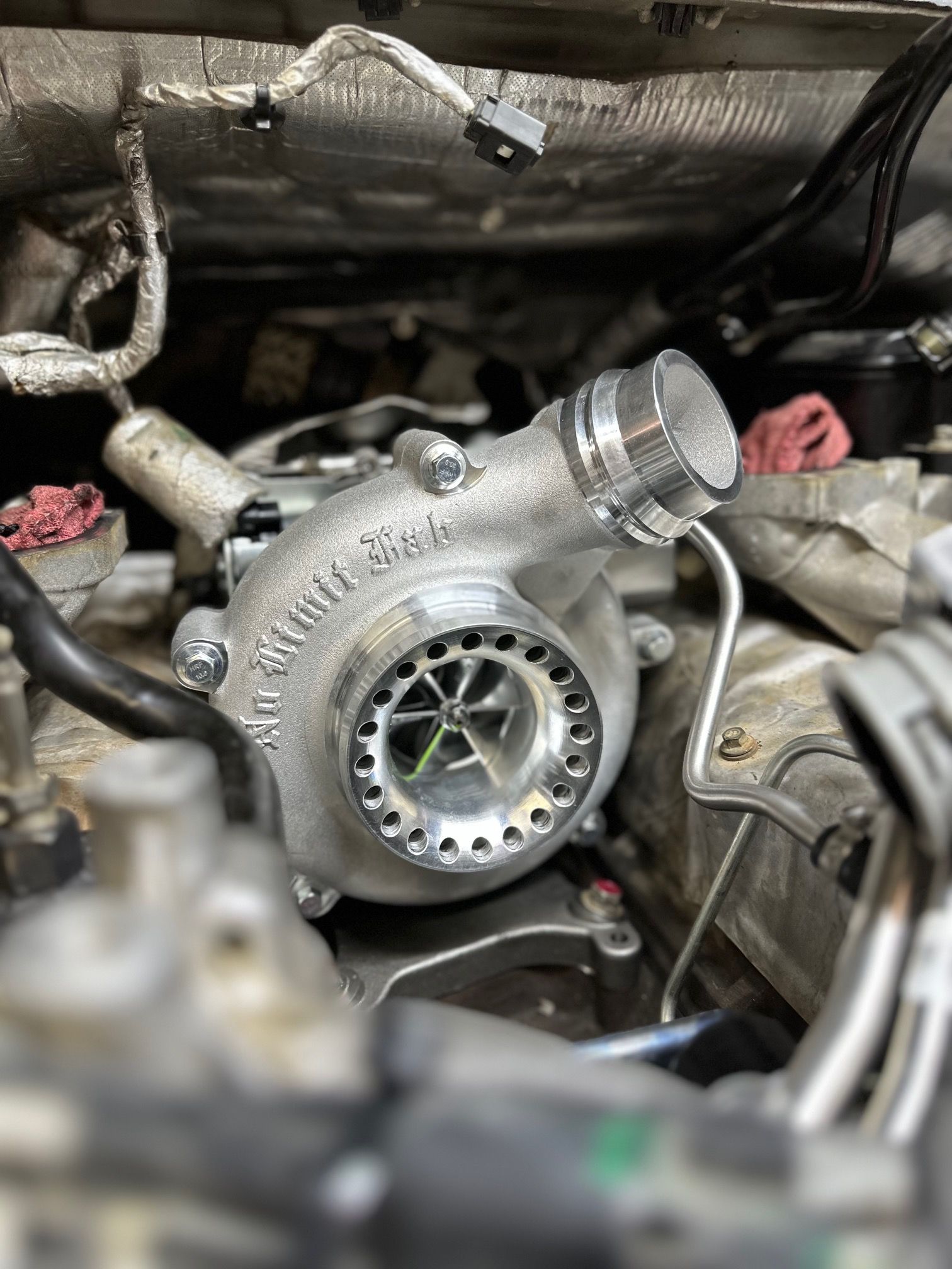 A turbocharger is sitting inside of a car engine.