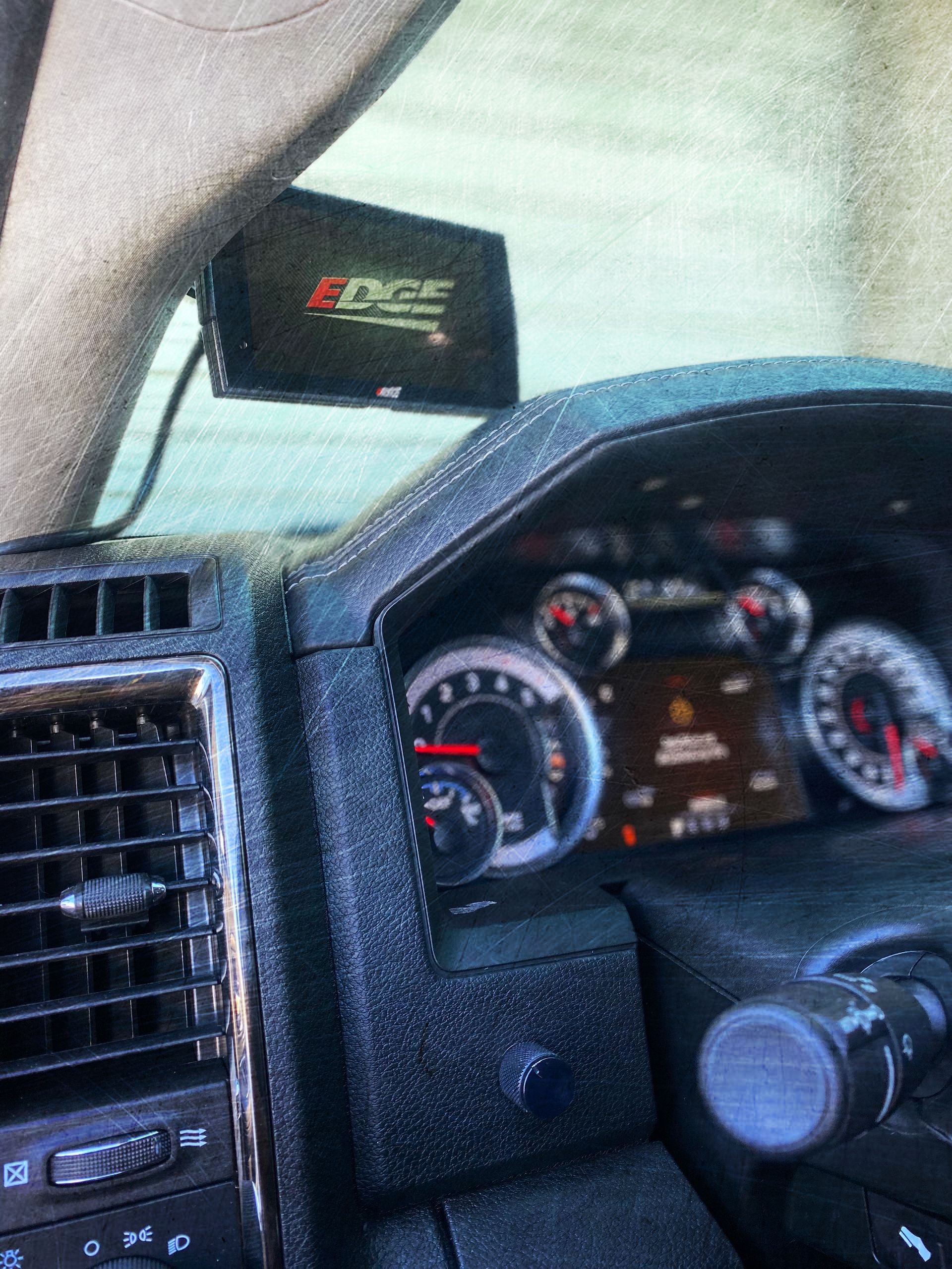 A close up of a car dashboard with a monitor mounted on it
