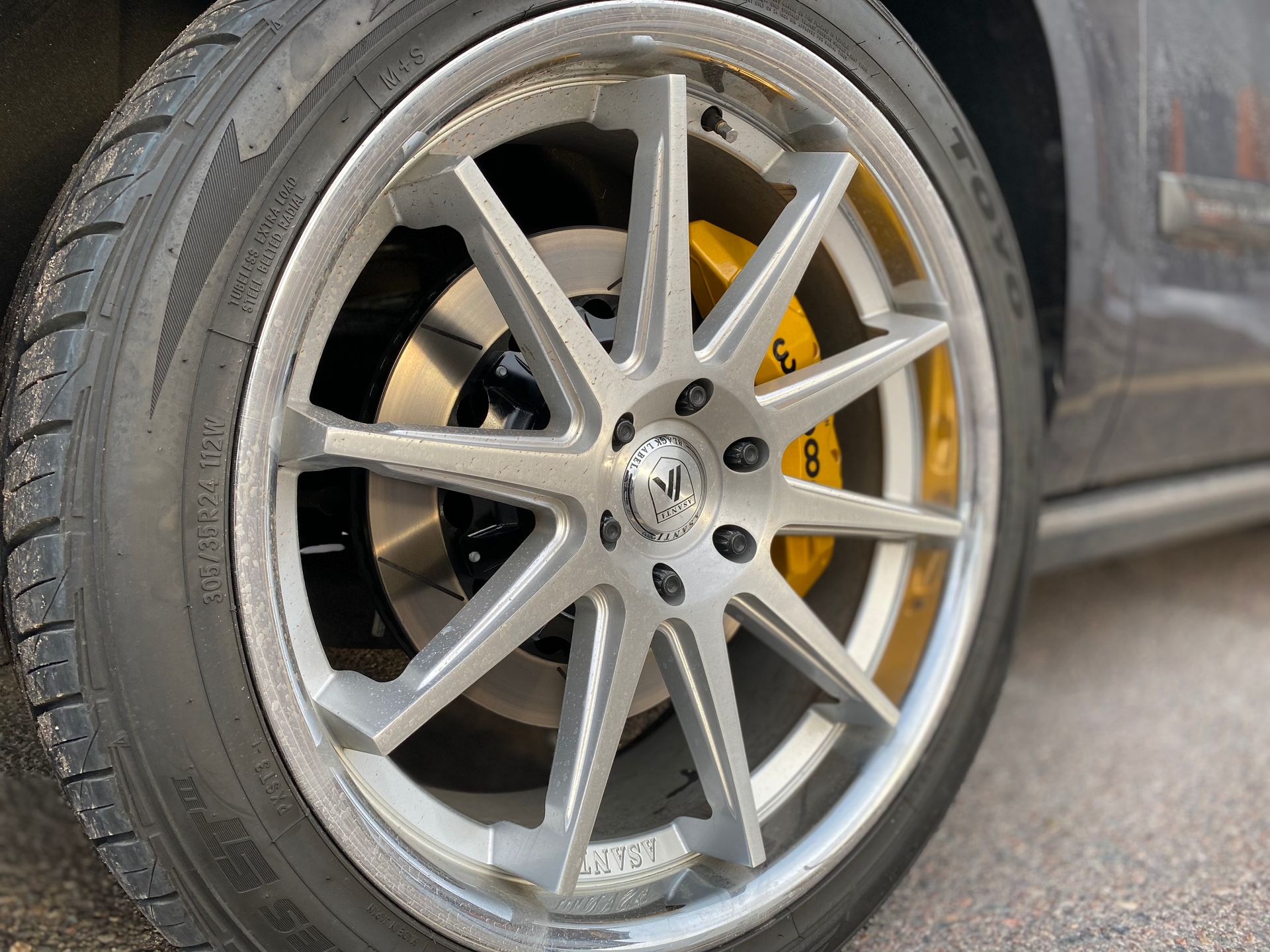 A close up of a car wheel with yellow brake calipers