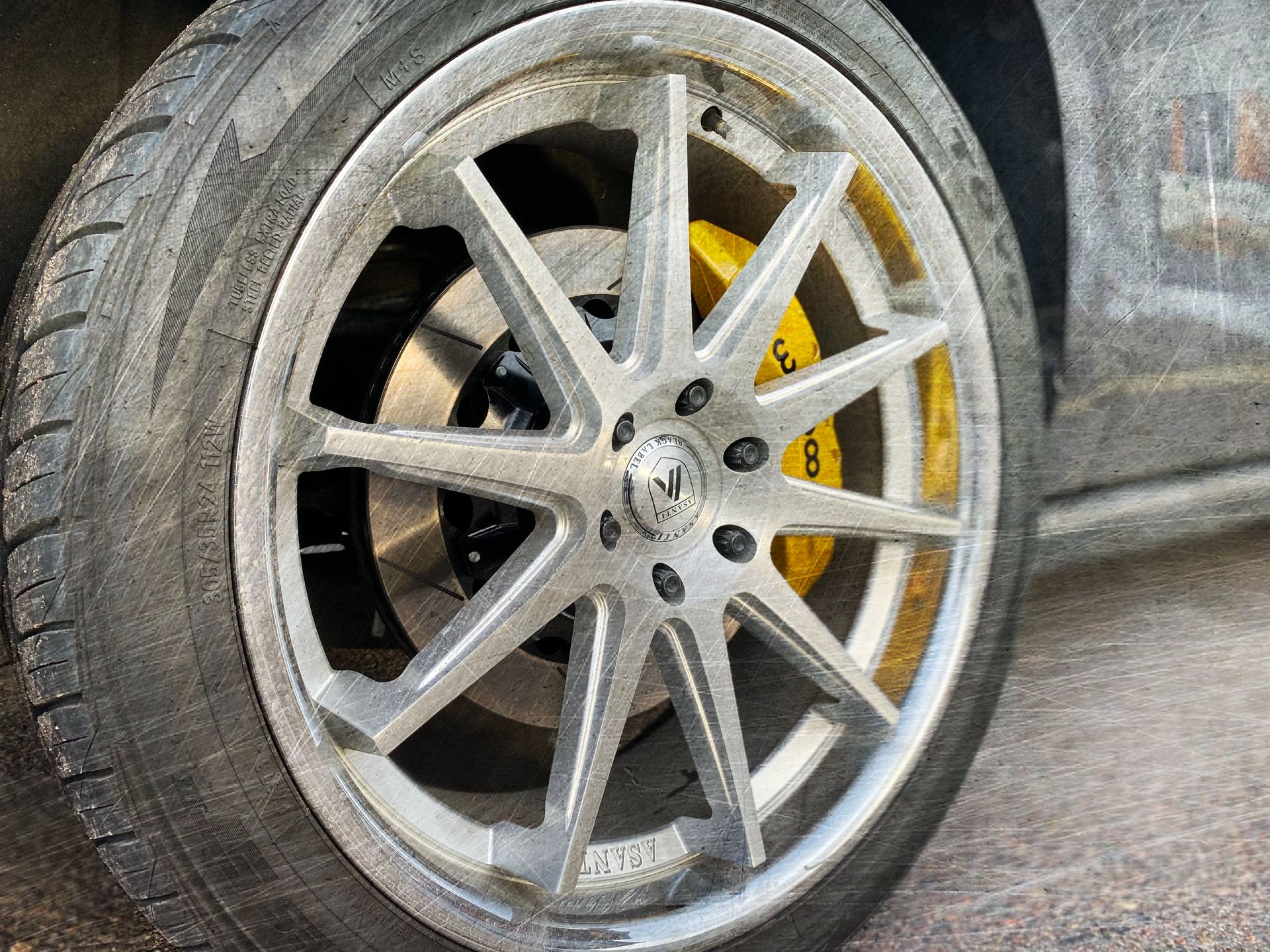 A close up of a car wheel with yellow brake calipers.