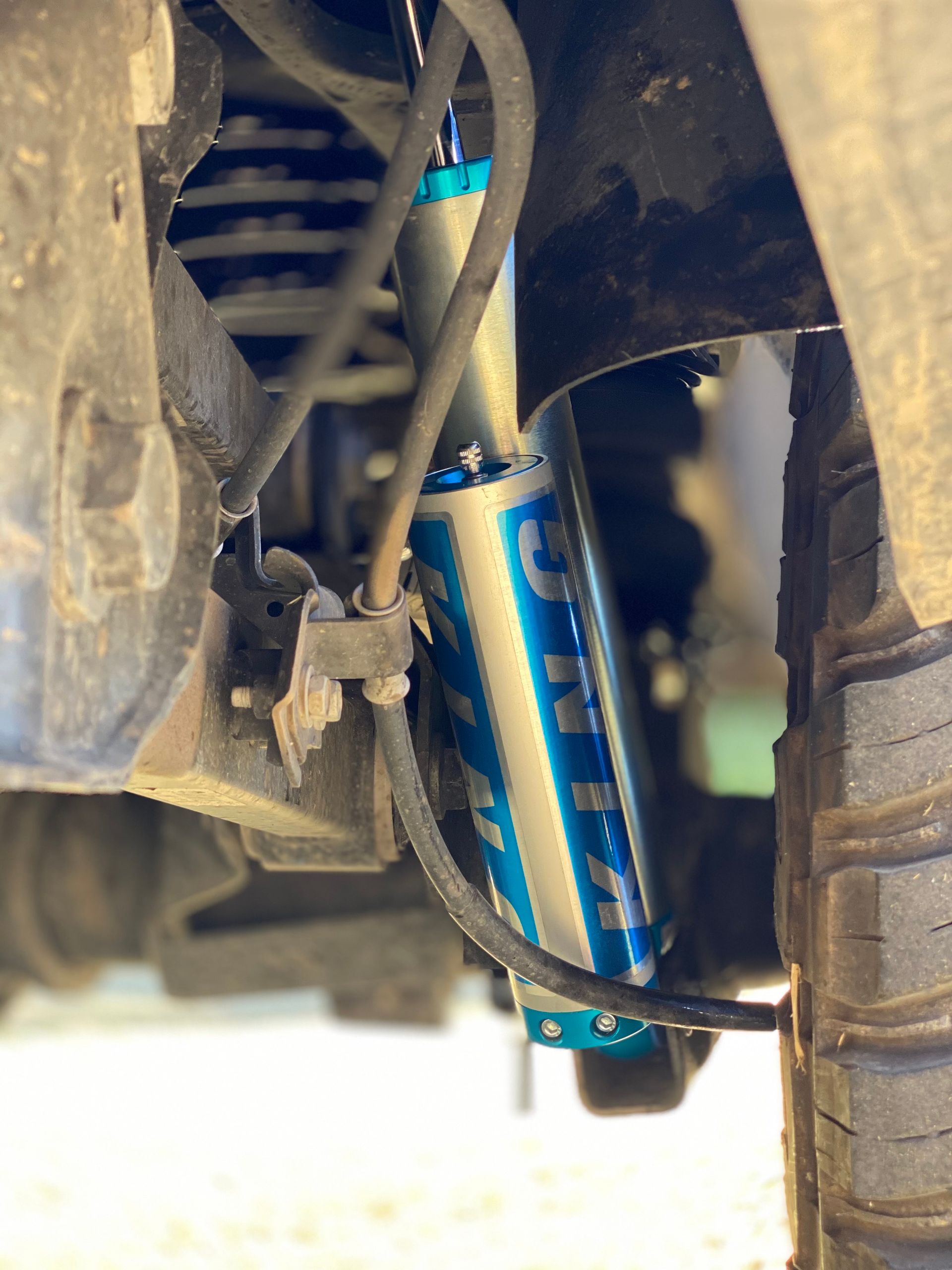 A close up of a shock absorber on a truck.
