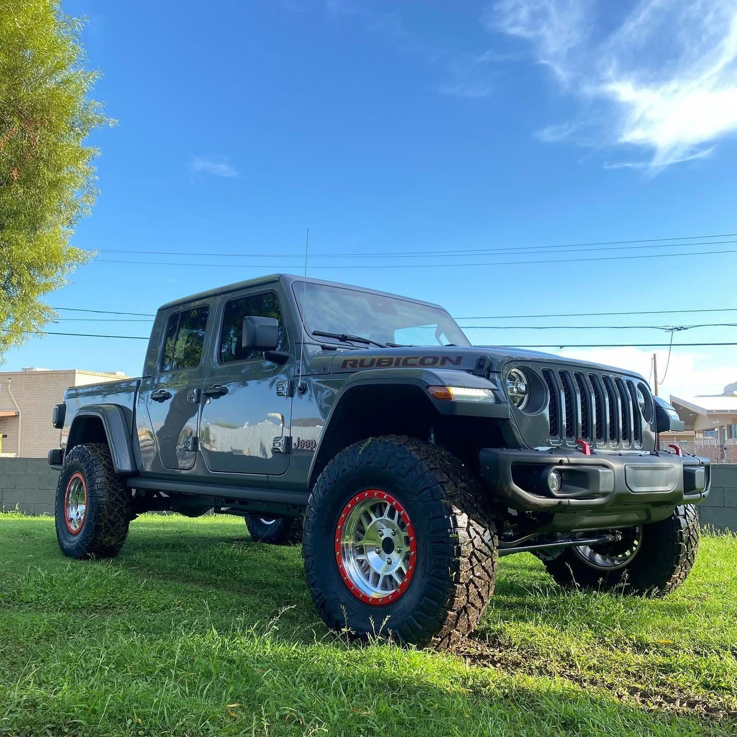 A jeep gladiator is parked in a grassy field.