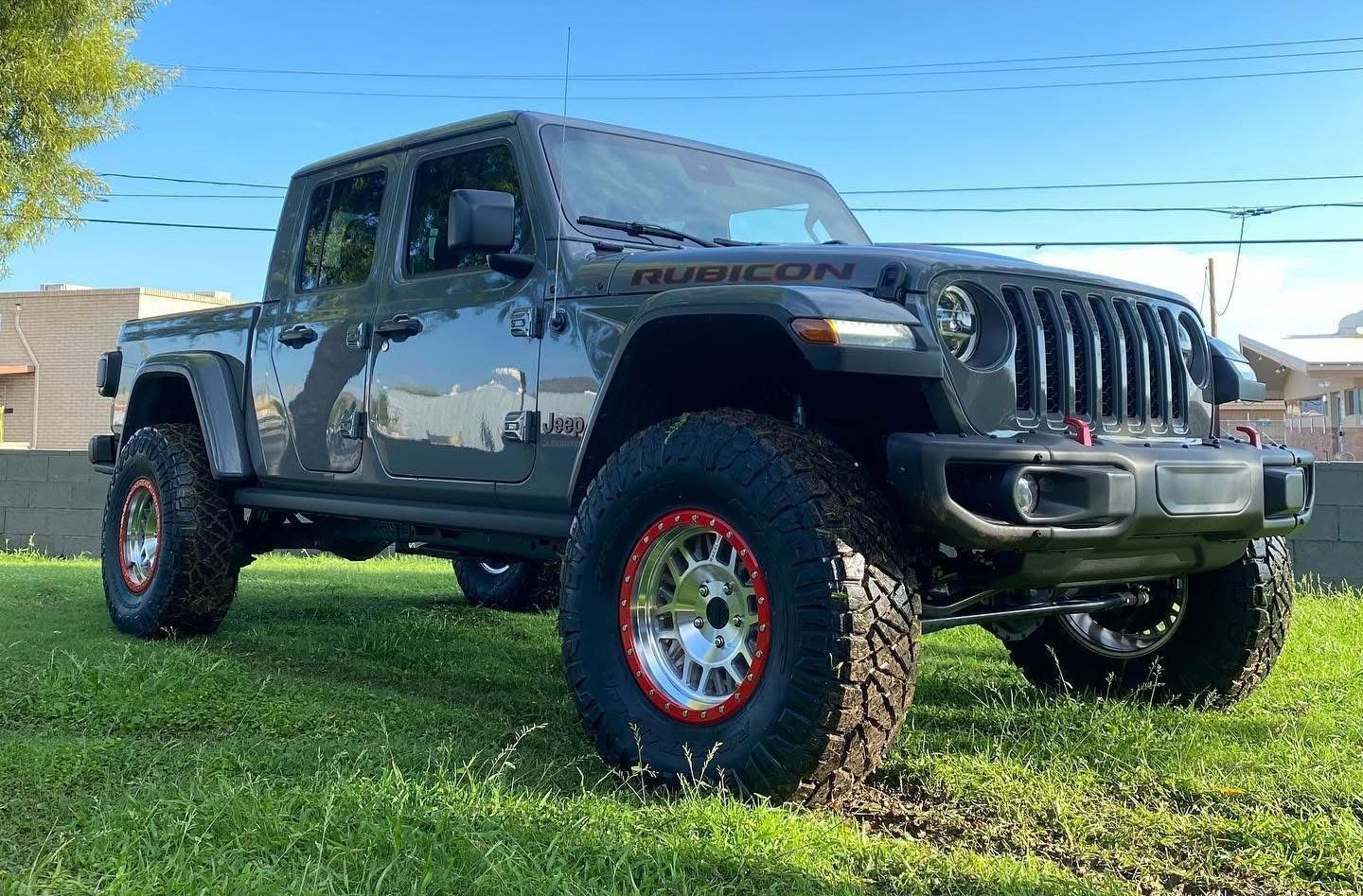 A jeep gladiator is parked in a grassy field.