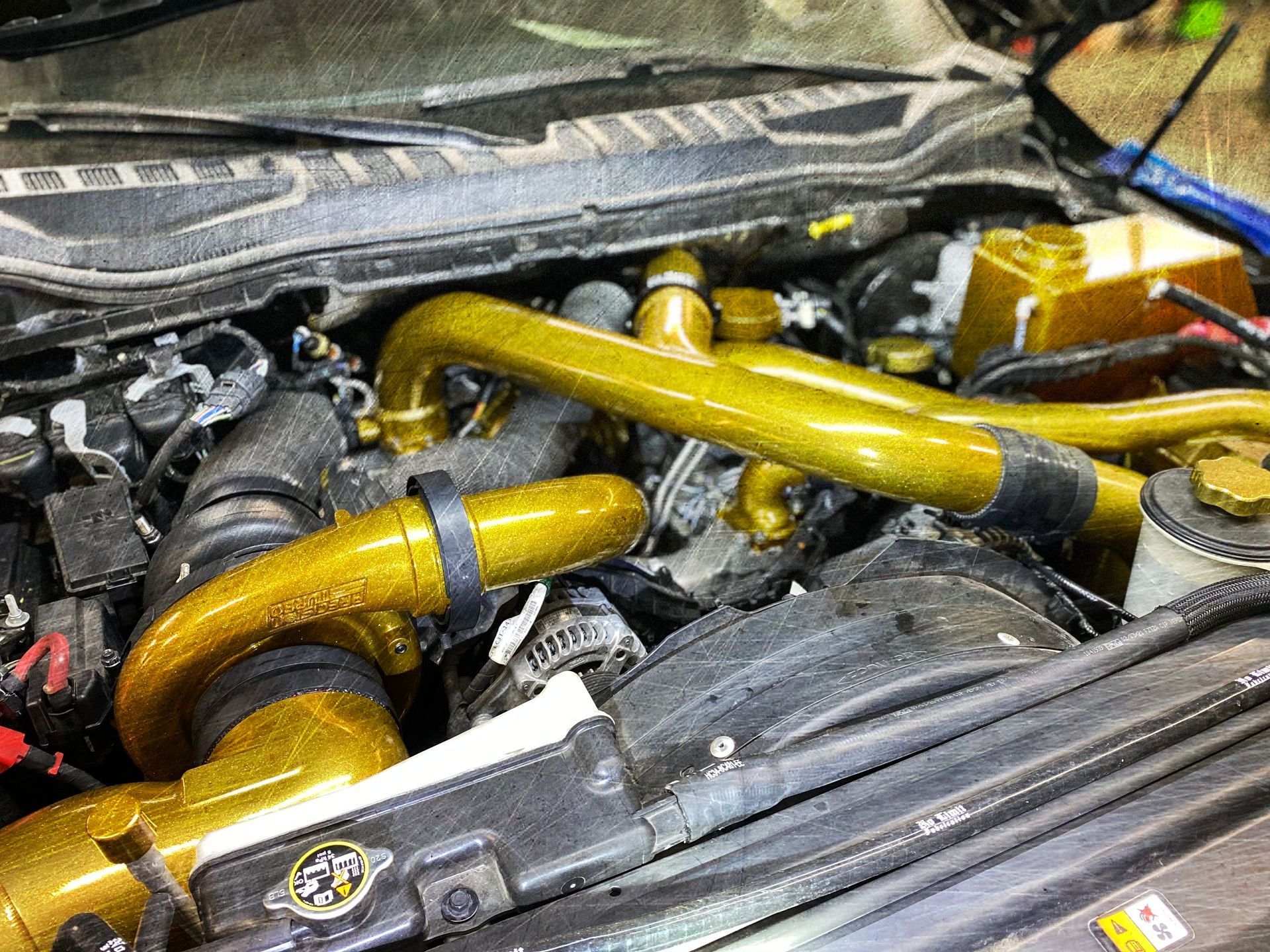 A close up of the engine of a car with the hood open.