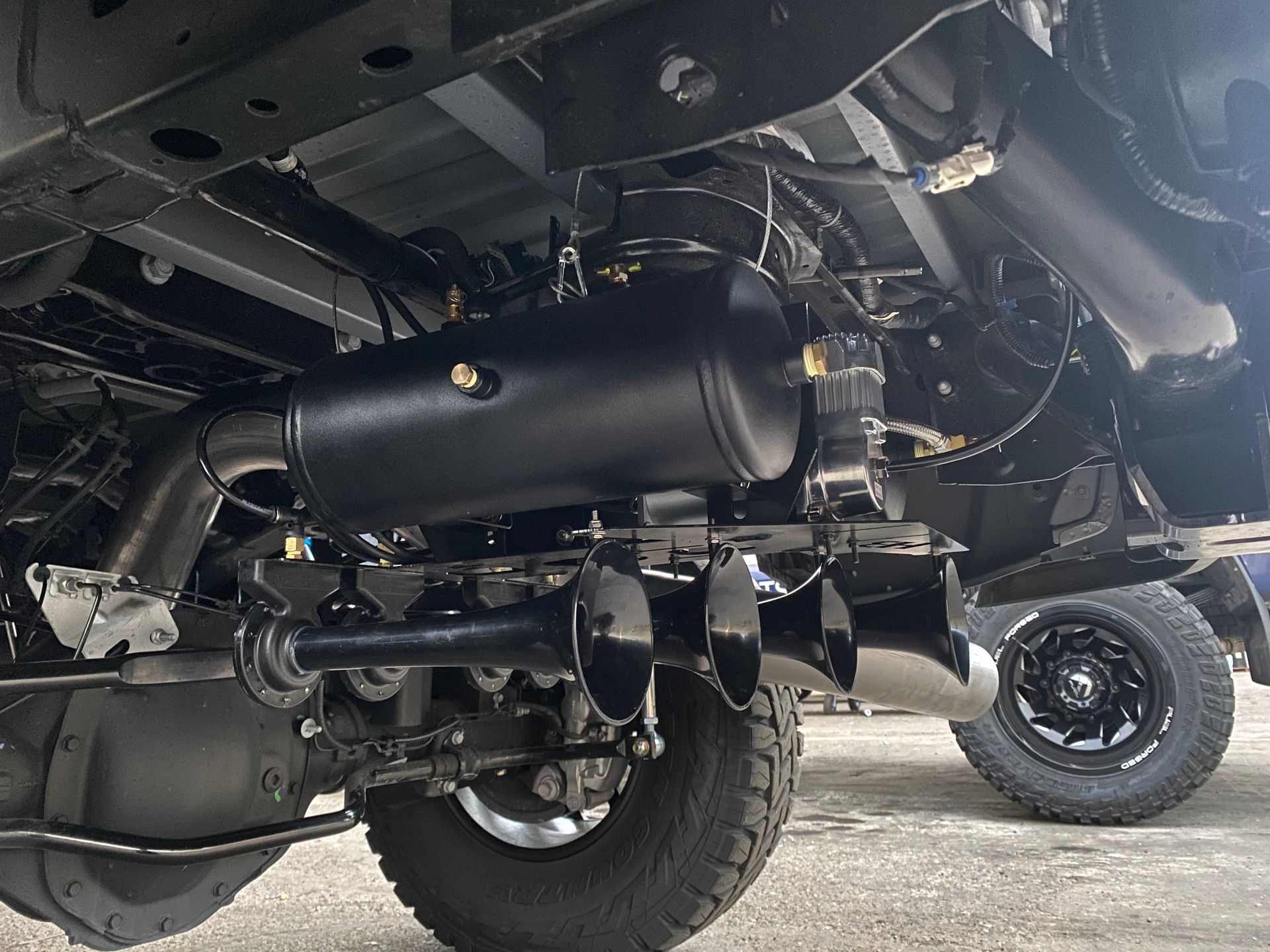 The underside of a truck with a horn attached to it.