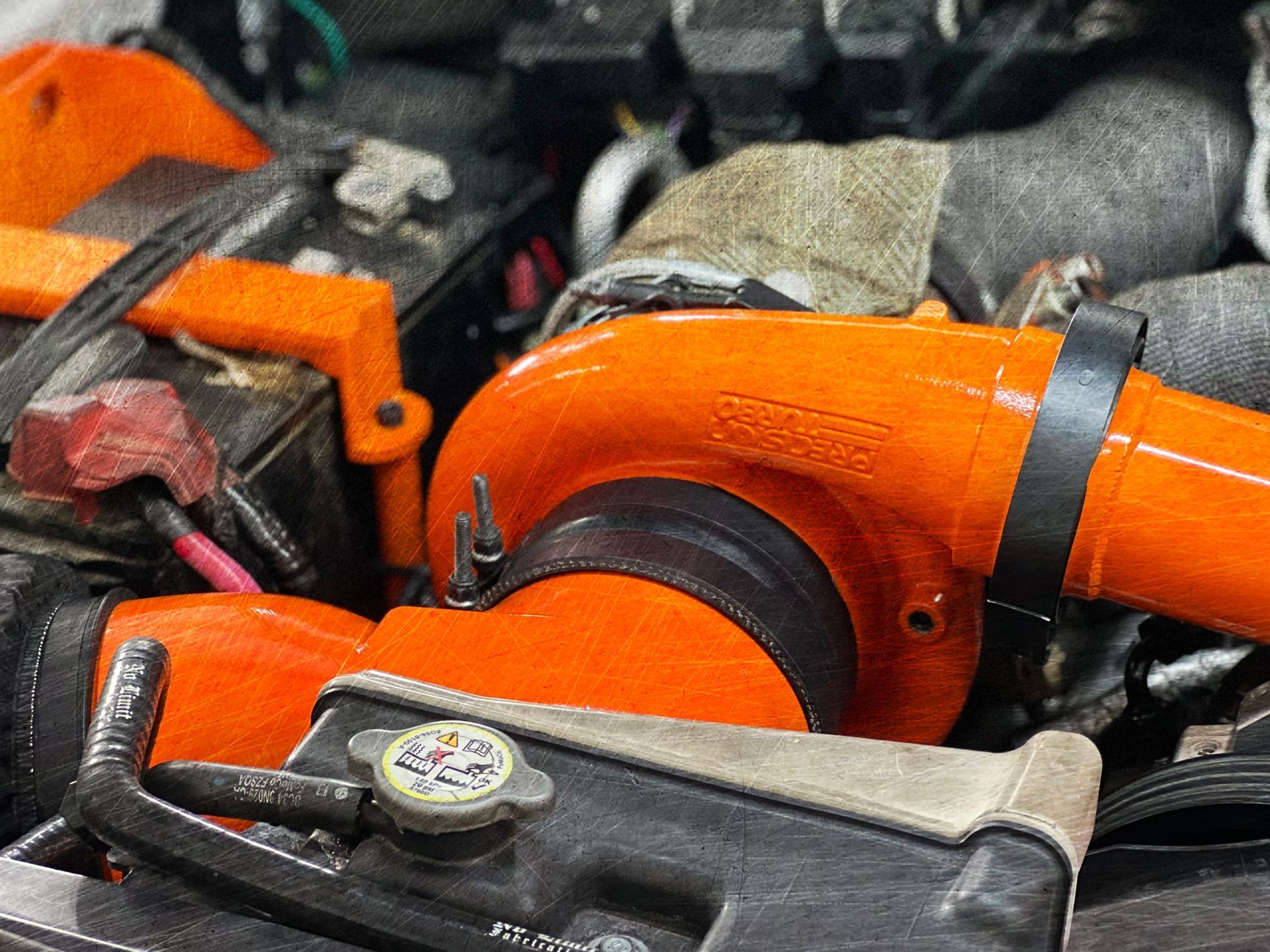 A close up of a car engine with an orange turbo.