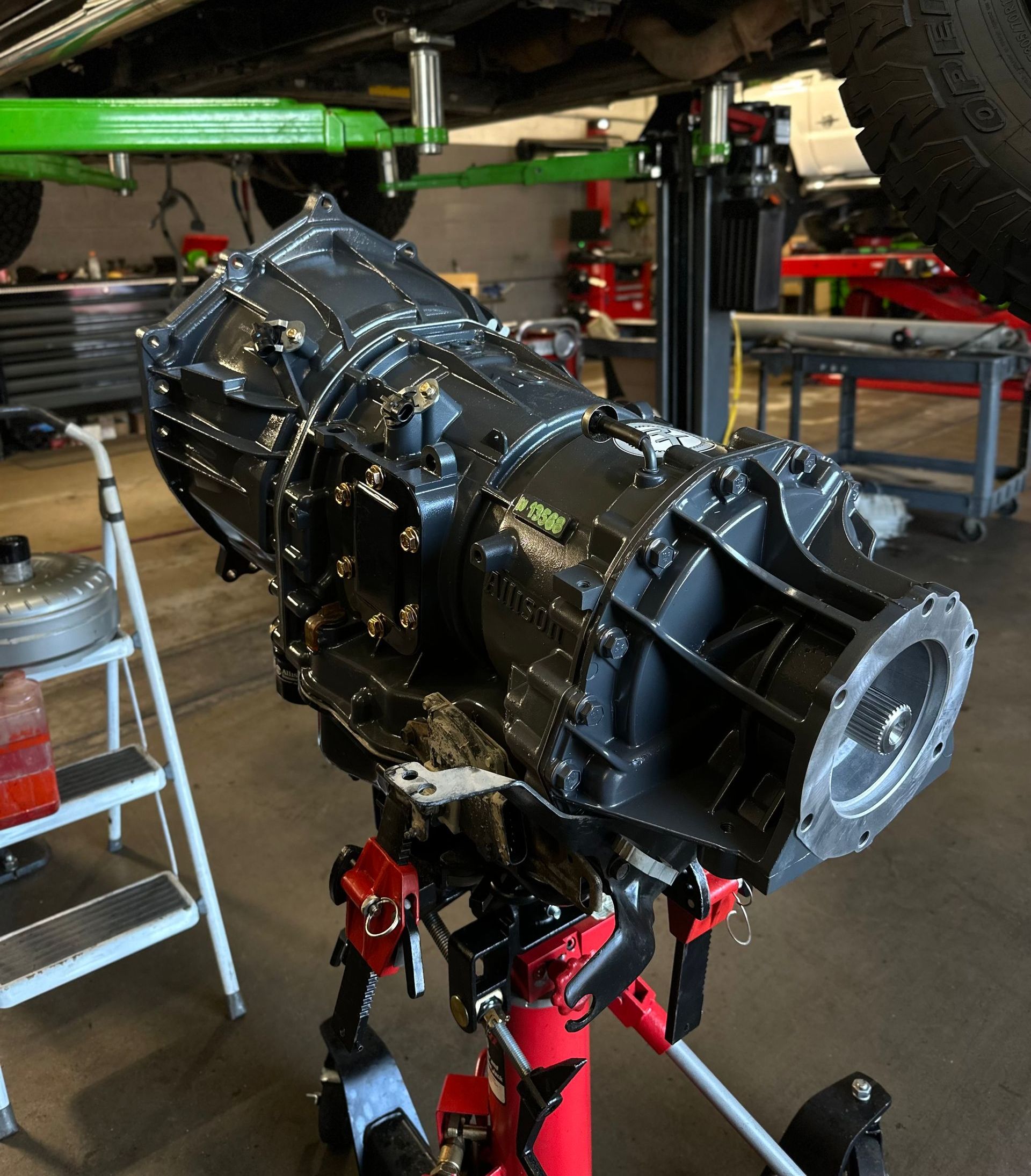 A black gearbox is sitting on a stand in a garage