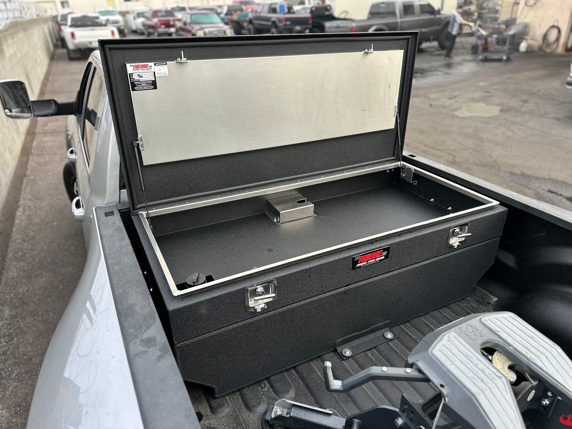 A truck with the bed open and a toolbox in the back.