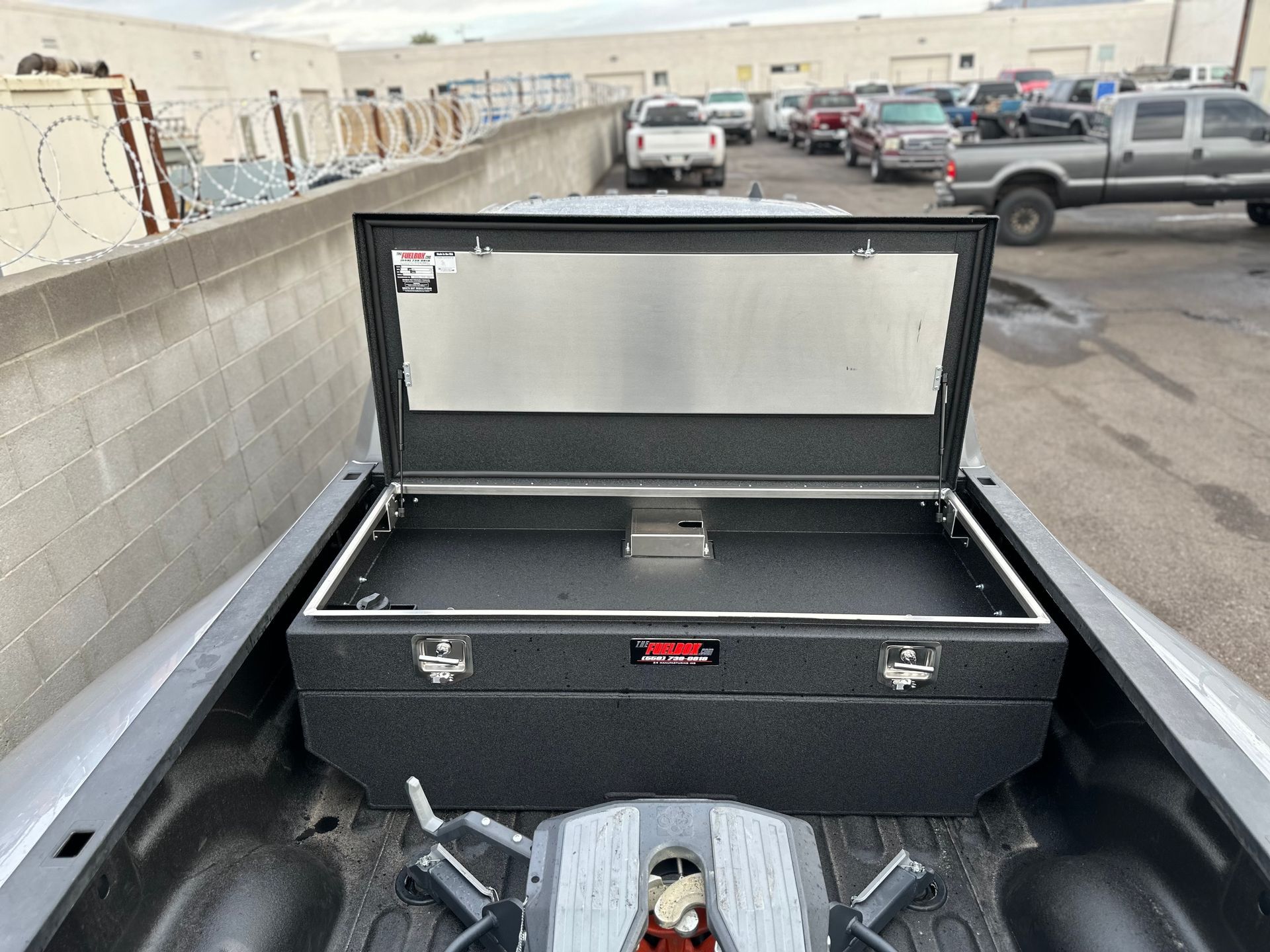 The back of a truck with the lid open and a trailer attached to it.