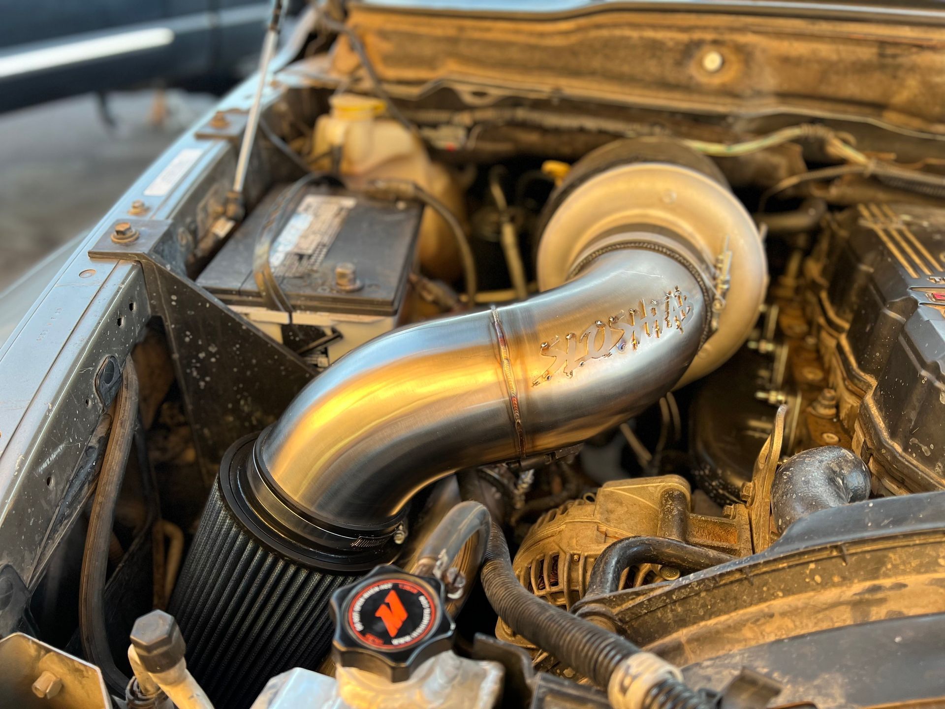 A close up of the engine of a car with a turbocharger.