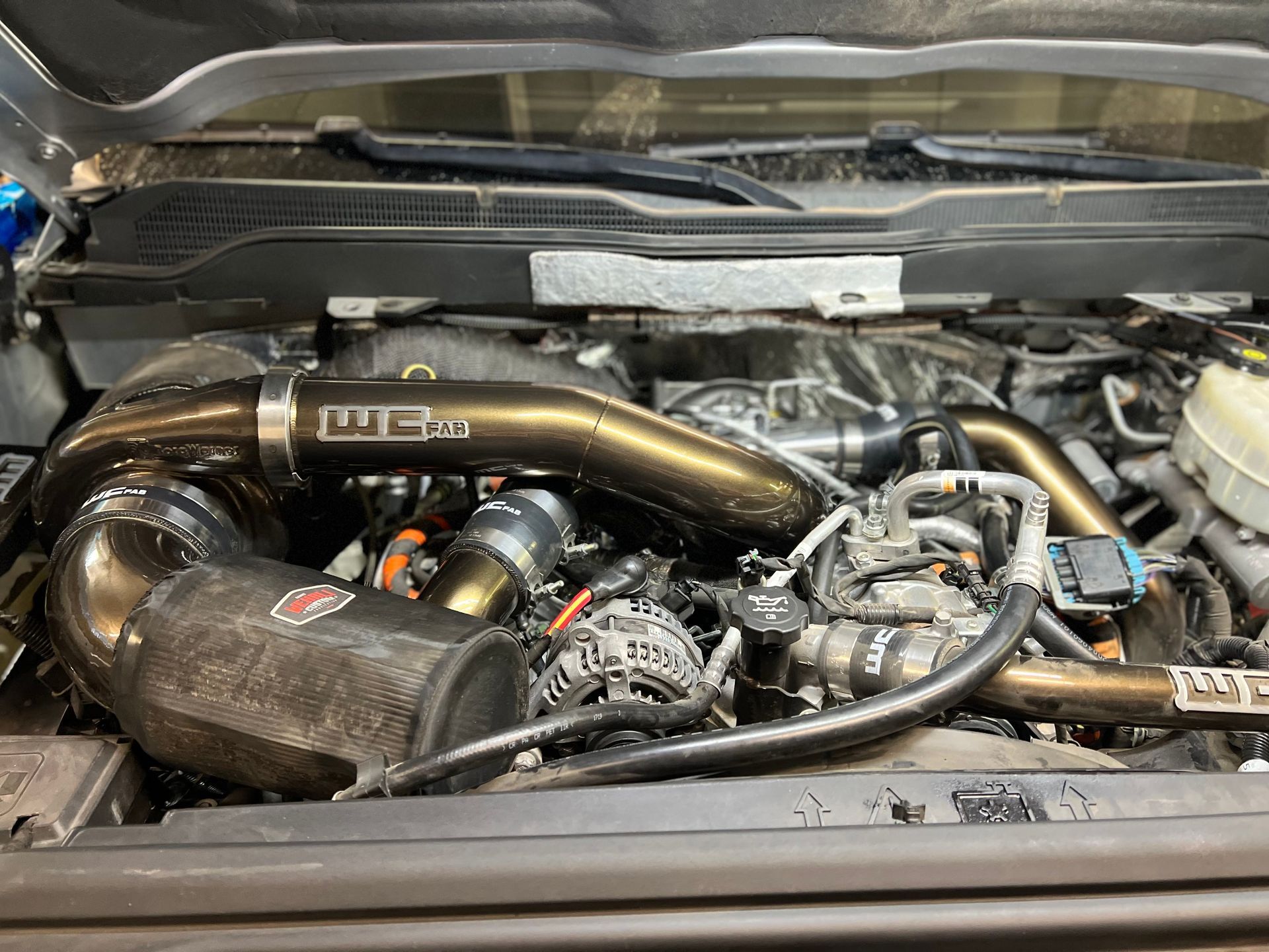 A close up of a car engine with the hood open.