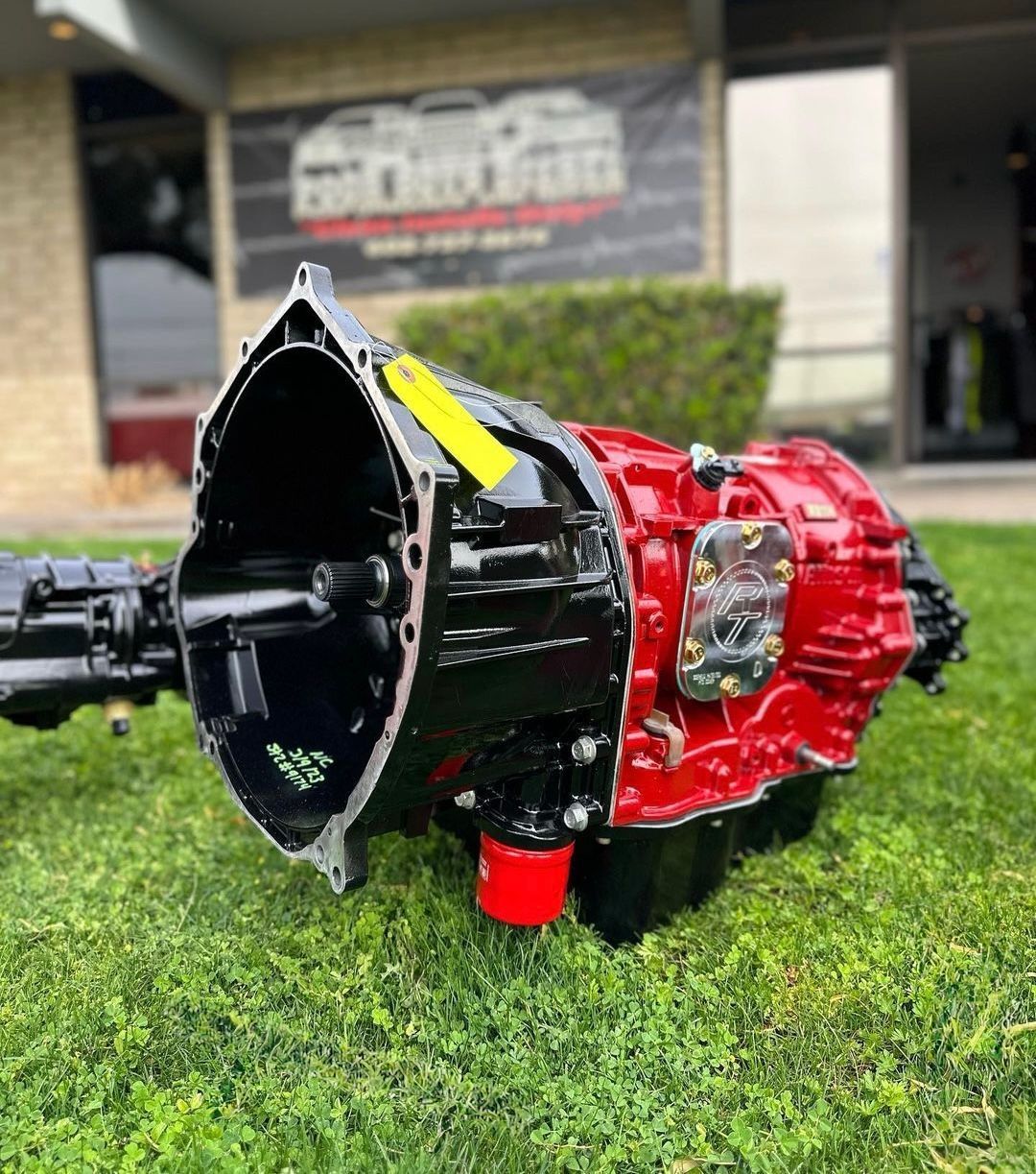 A black gearbox is sitting on a stand in a garage