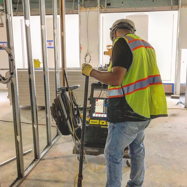 A man in a yellow vest is working on a machine
