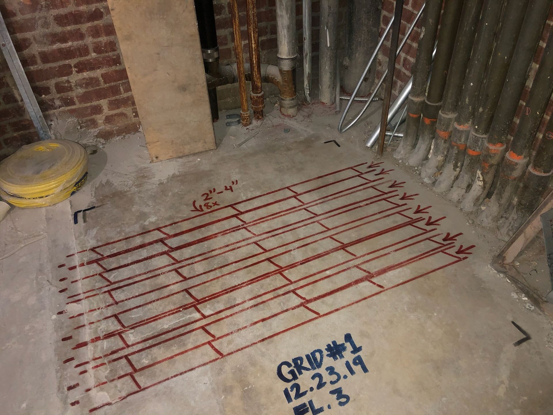 A man wearing a hard hat is working on a wall