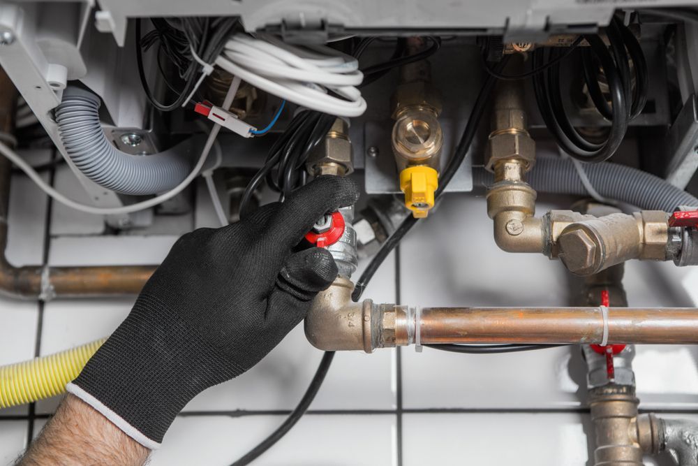Gloved Hand Adjusting a Valve on a Pipe — RAW Plumbing & Gasfitting in Tuggeranong, ACT
