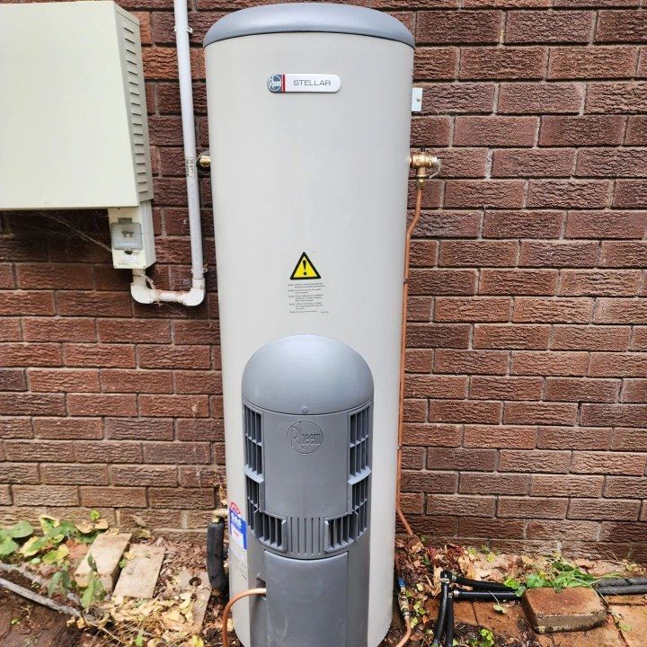 A Water Heater Is Sitting Outside Of A Brick Building —  RAW Plumbing & Gasfitting In Pearce, ACT