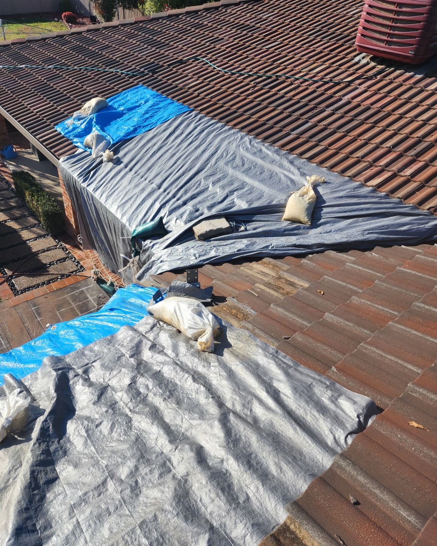 A Roof Is Covered In Tarps And Bags Of Sand —  RAW Plumbing & Gasfitting In Pearce, ACT