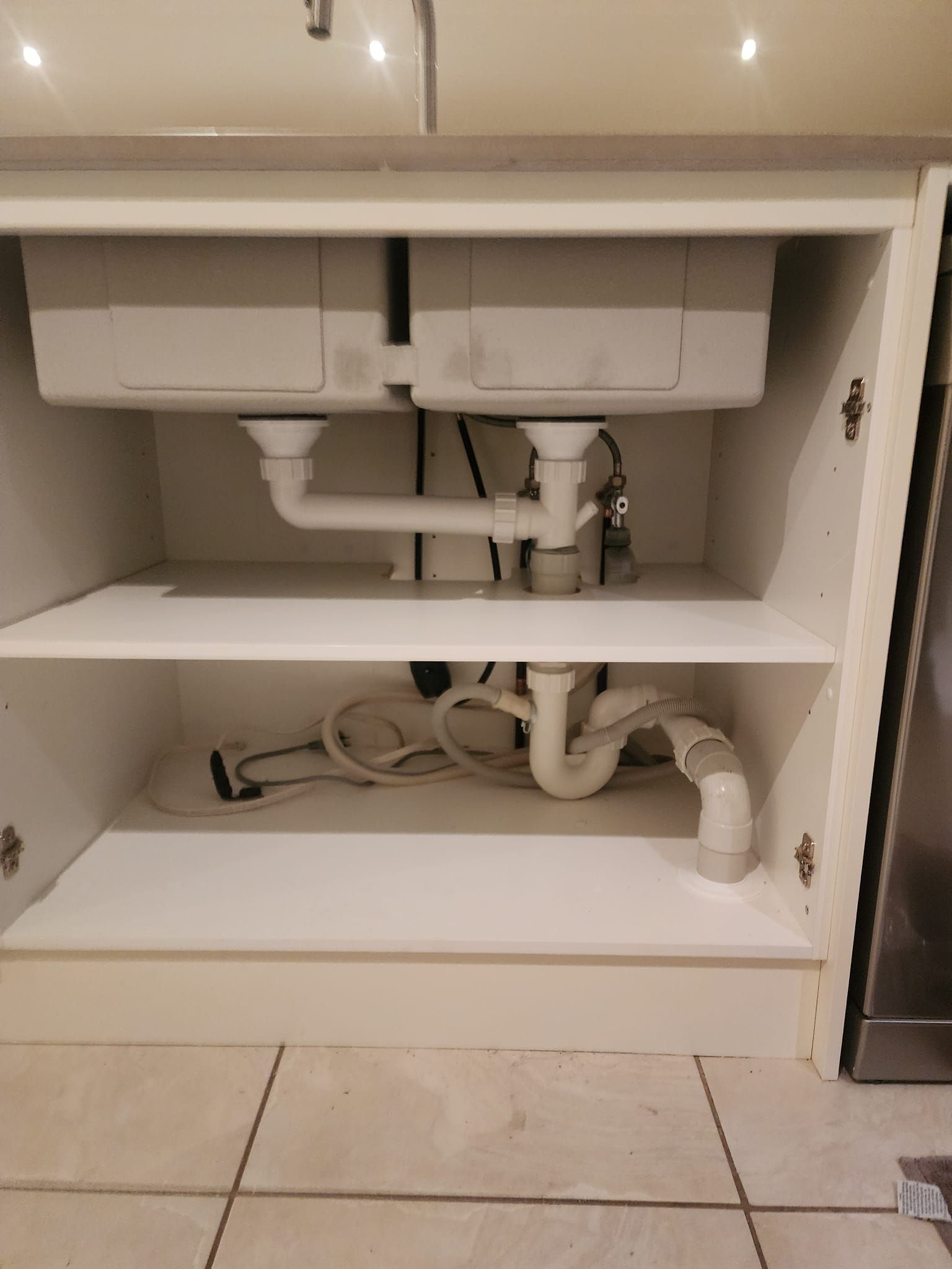 A Kitchen Sink Is Sitting Under A Cabinet With Pipes Coming Out Of It —  RAW Plumbing & Gasfitting In Pearce, ACT