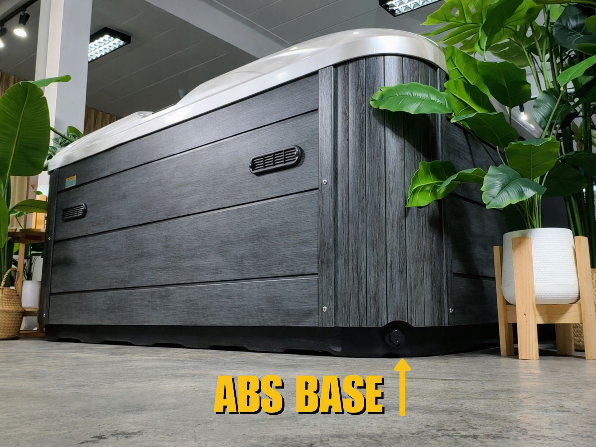 Black ABS base structure underneath an outdoor hot tub for moisture and structural protection