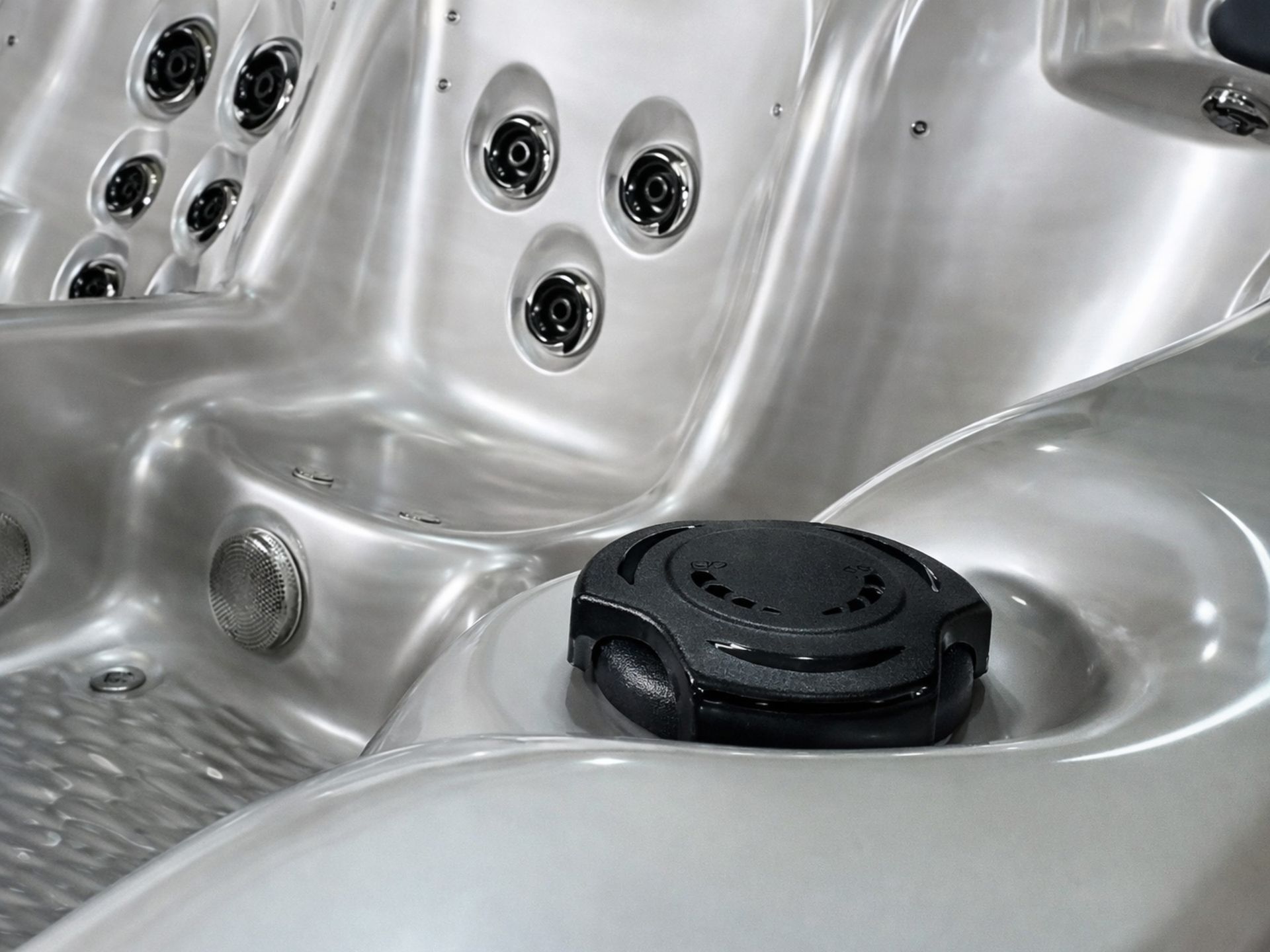 Black air control valve inside a hot tub used to adjust jet pressure and massage intensity