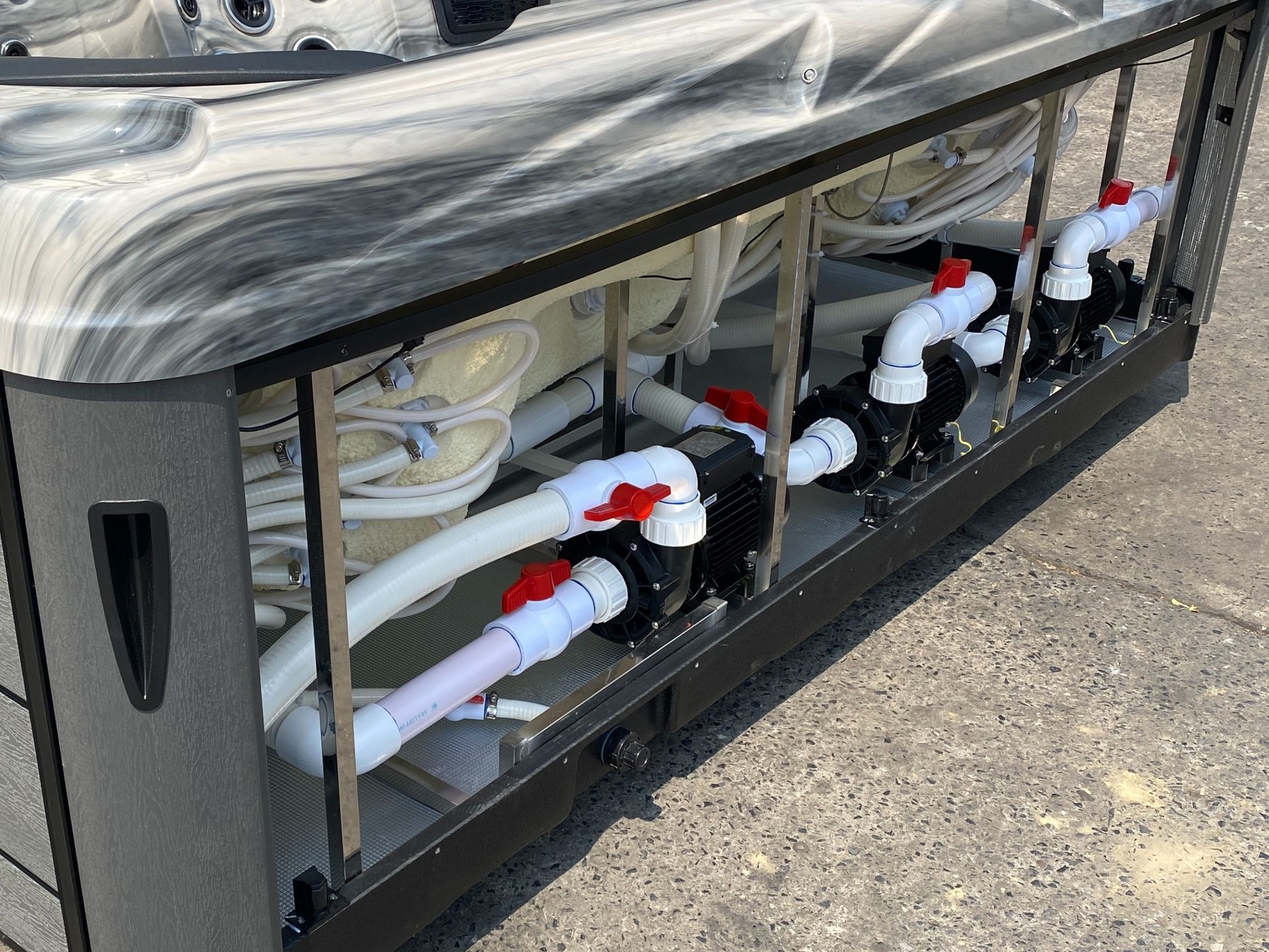 ภาพโครงสร้างภายในอ่างน้ำร้อนแสดงระบบปั๊มหลายชุด พร้อมท่อและวาล์วควบคุม ออกแบบให้แยกการทำงานตามหน้าที่ เช่น ระบบนวดเจ็ทและระบบหมุนเวียนน้ำ เพื่อเพิ่มประสิทธิภาพการทำงาน ลดภาระของมอเตอร์ และช่วยยืดอายุการใช้งานของอุปกรณ์โดยรวม