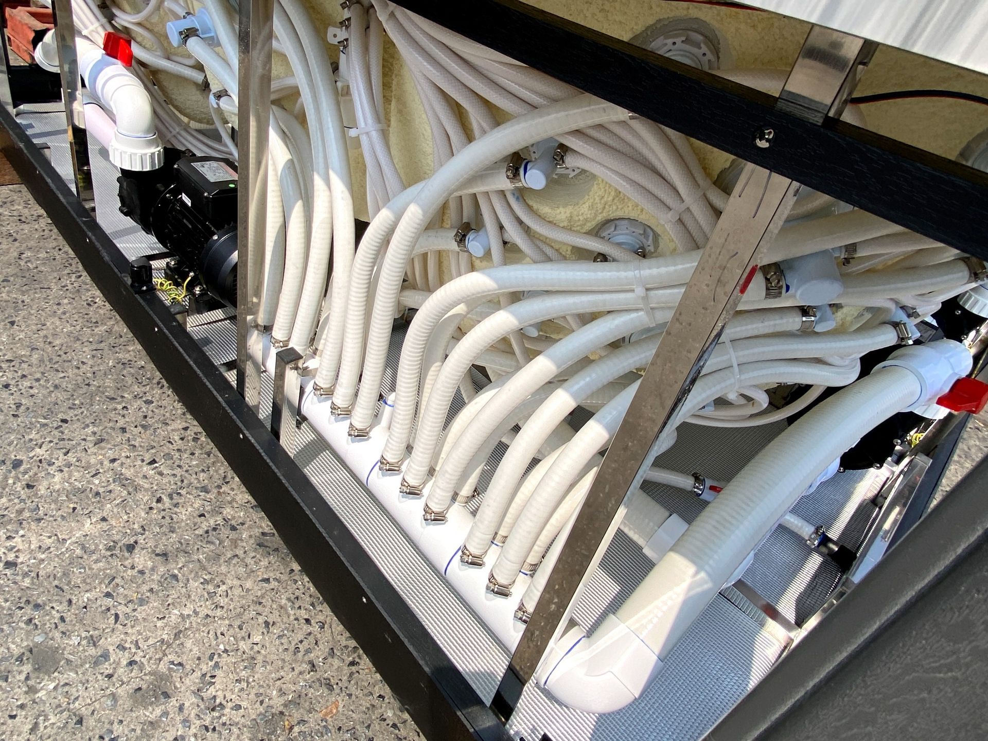 ภาพแสดงระบบติดตั้งท่อน้ำภายในอ่างน้ำร้อน โดยใช้กาวประสานท่ออุตสาหกรรมสำหรับ hot tub เพื่อซีลรอยต่ออย่างแน่นหนา พร้อมแคลป์รัดท่อสแตนเลสในระบบนวดเจ็ท ช่วยป้องกันการรั่วซึม เพิ่มความแข็งแรงของระบบไหลเวียนน้ำ และรองรับแรงดันในการใช้งานระยะยาว