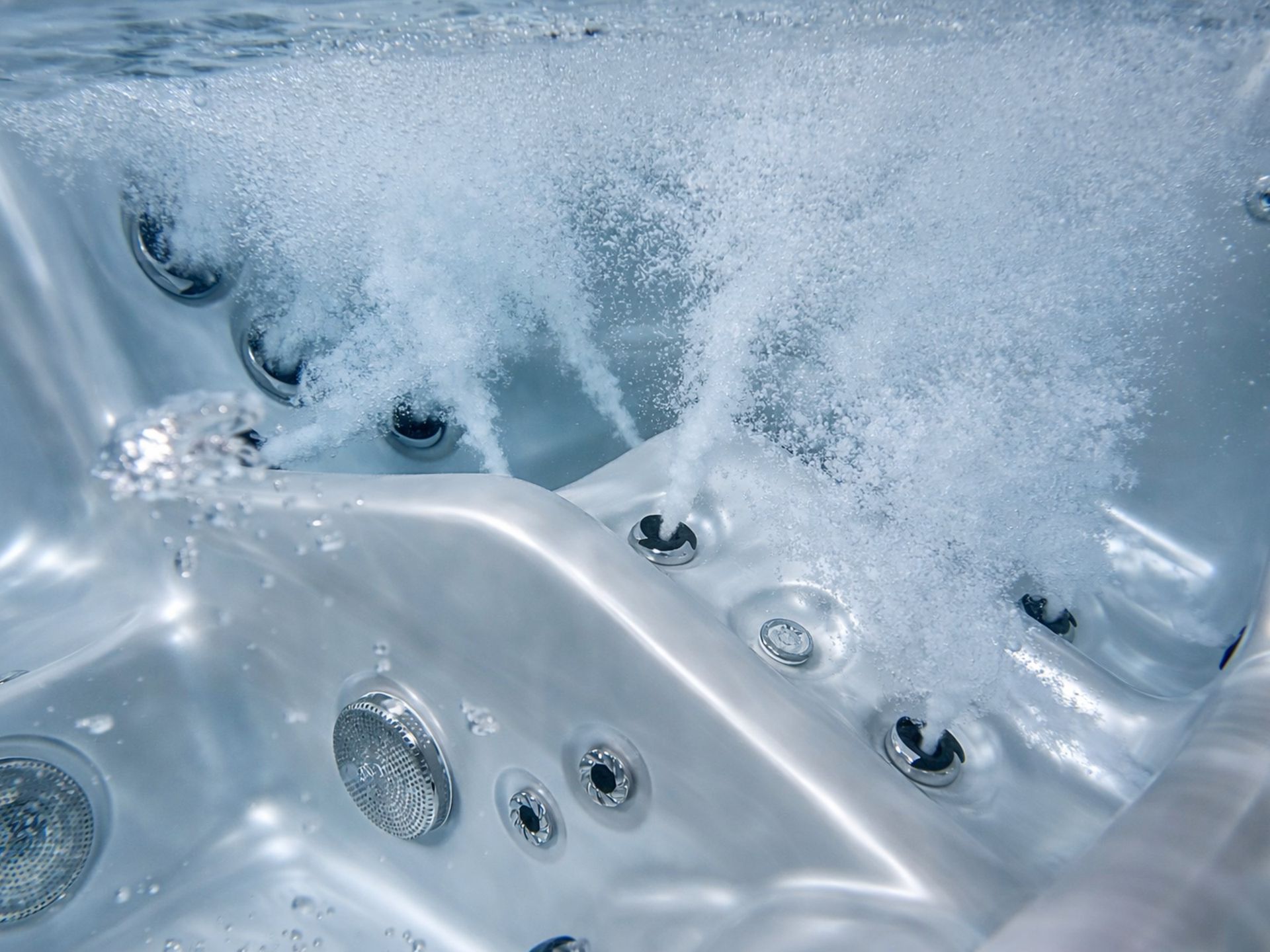 Close-up of MARINA hot tub underwater massage jets in action, showing high-pressure hydrotherapy bubbles for deep muscle relaxation.