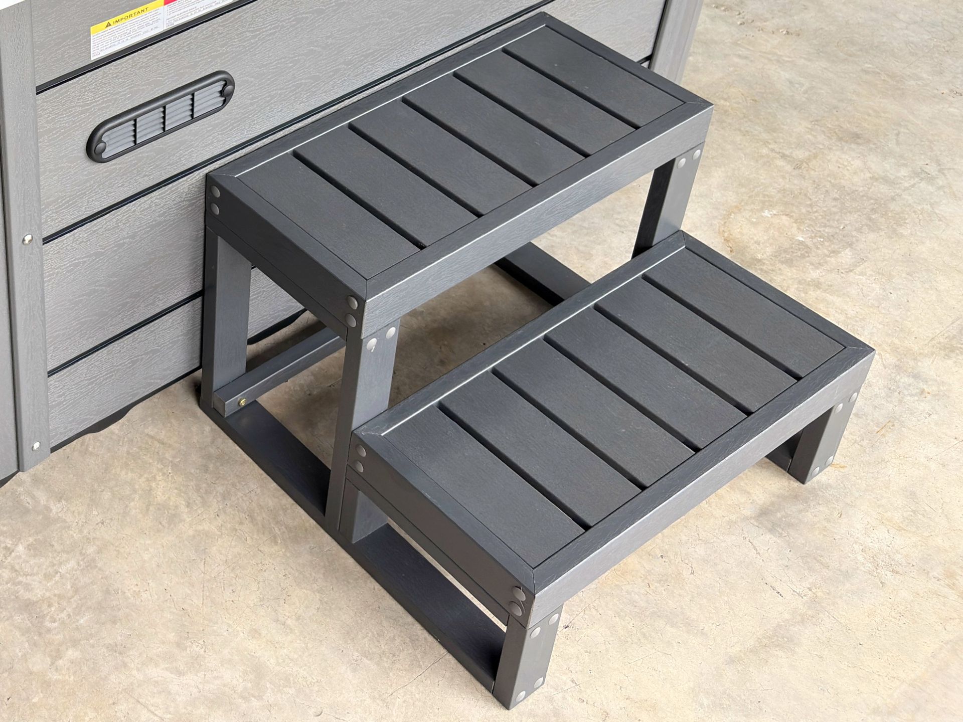 ภาพบันไดภายนอกสำหรับอ่างน้ำร้อน ดีไซน์สองขั้น ผลิตจากวัสดุแข็งแรงทนความชื้น โครงสร้างมั่นคง ช่วยให้การขึ้นลงอ่างน้ำร้อนสะดวกและปลอดภัย เหมาะสำหรับติดตั้งทั้งภายในและภายนอกอาคาร