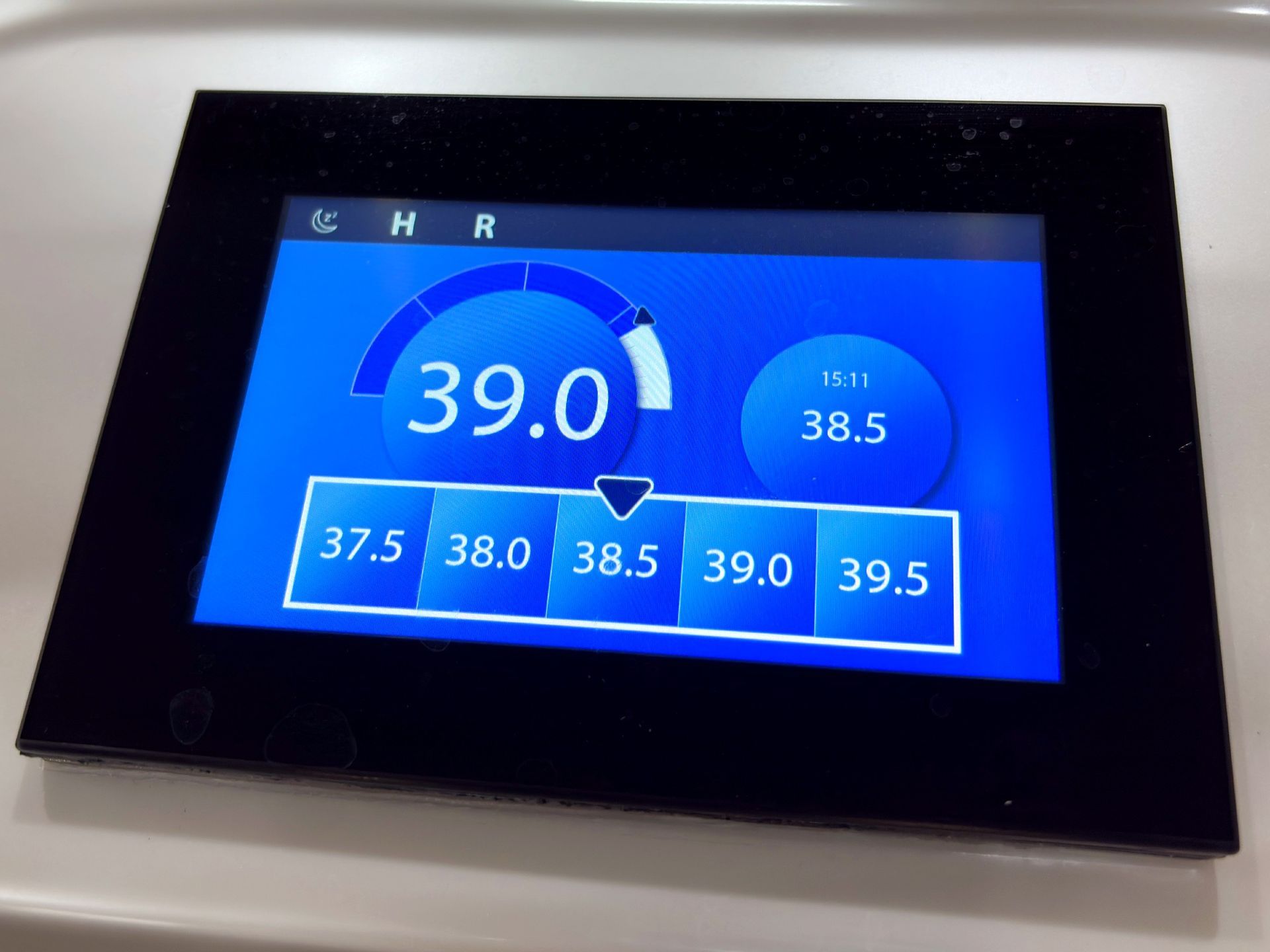 หน้าจอควบคุมแบบสัมผัสดิจิทัลของอ่างน้ำร้อน แสดงอุณหภูมิน้ำ 39 องศาเซลเซียส พร้อมตัวเลือกปรับระดับอุณหภูมิและแสดงค่าแบบเรียลไทม์ ช่วยให้ผู้ใช้งานควบคุมการทำงานได้อย่างสะดวกและแม่นยำ