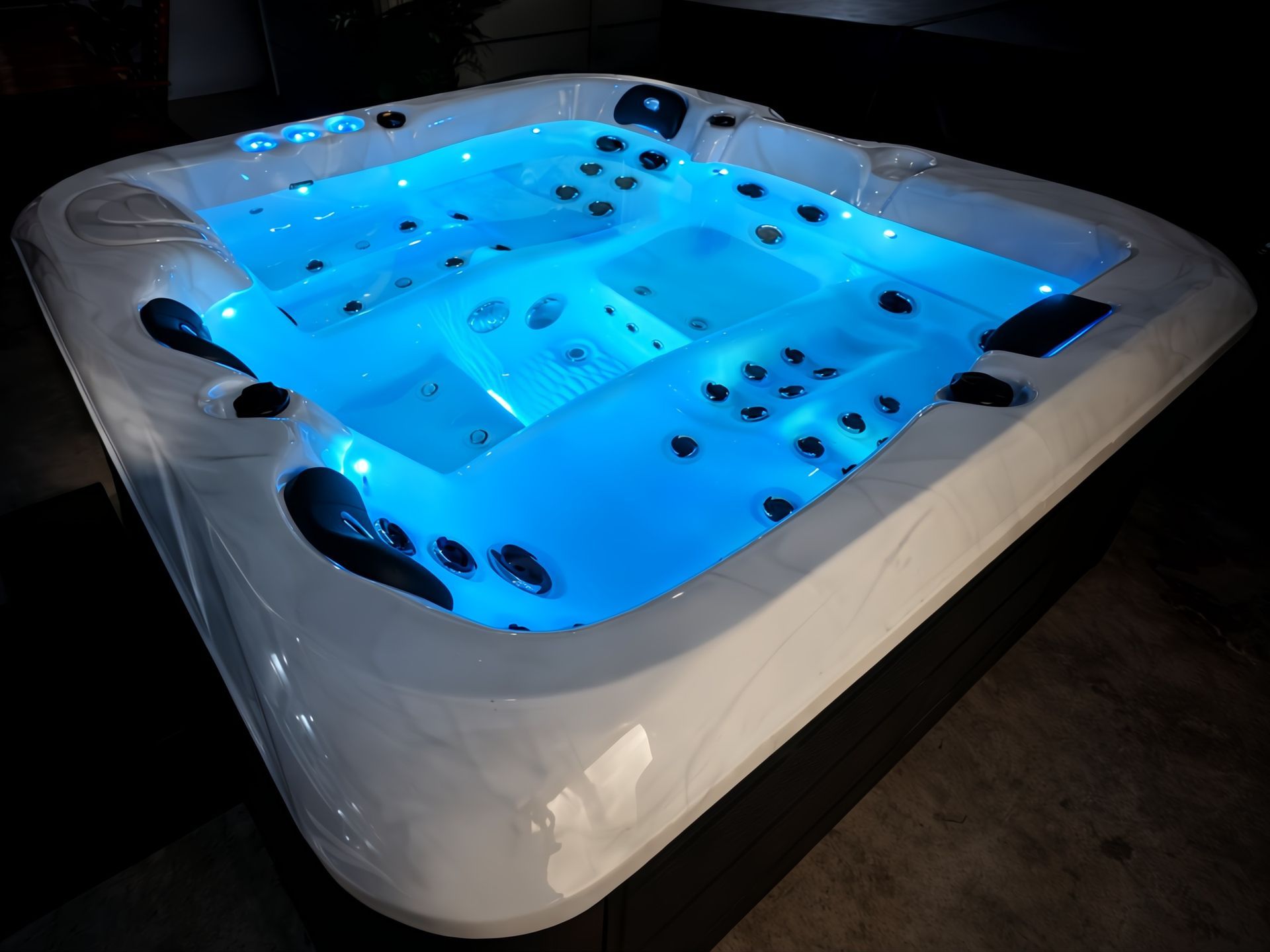 Image of a luxury hot tub featuring an 8-color LED lighting system, illuminating the water in blue tones to create a premium spa ambience at night. Ideal for residential homes, private villas, resorts, and pool villa installations in Thailand.