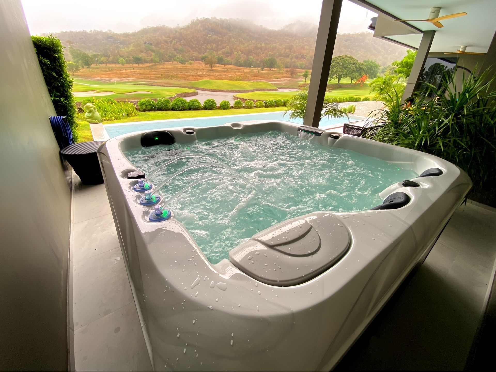 Outdoor hot tub with massage jets overlooking a golf course and mountain views at a luxury villa in Thailand
