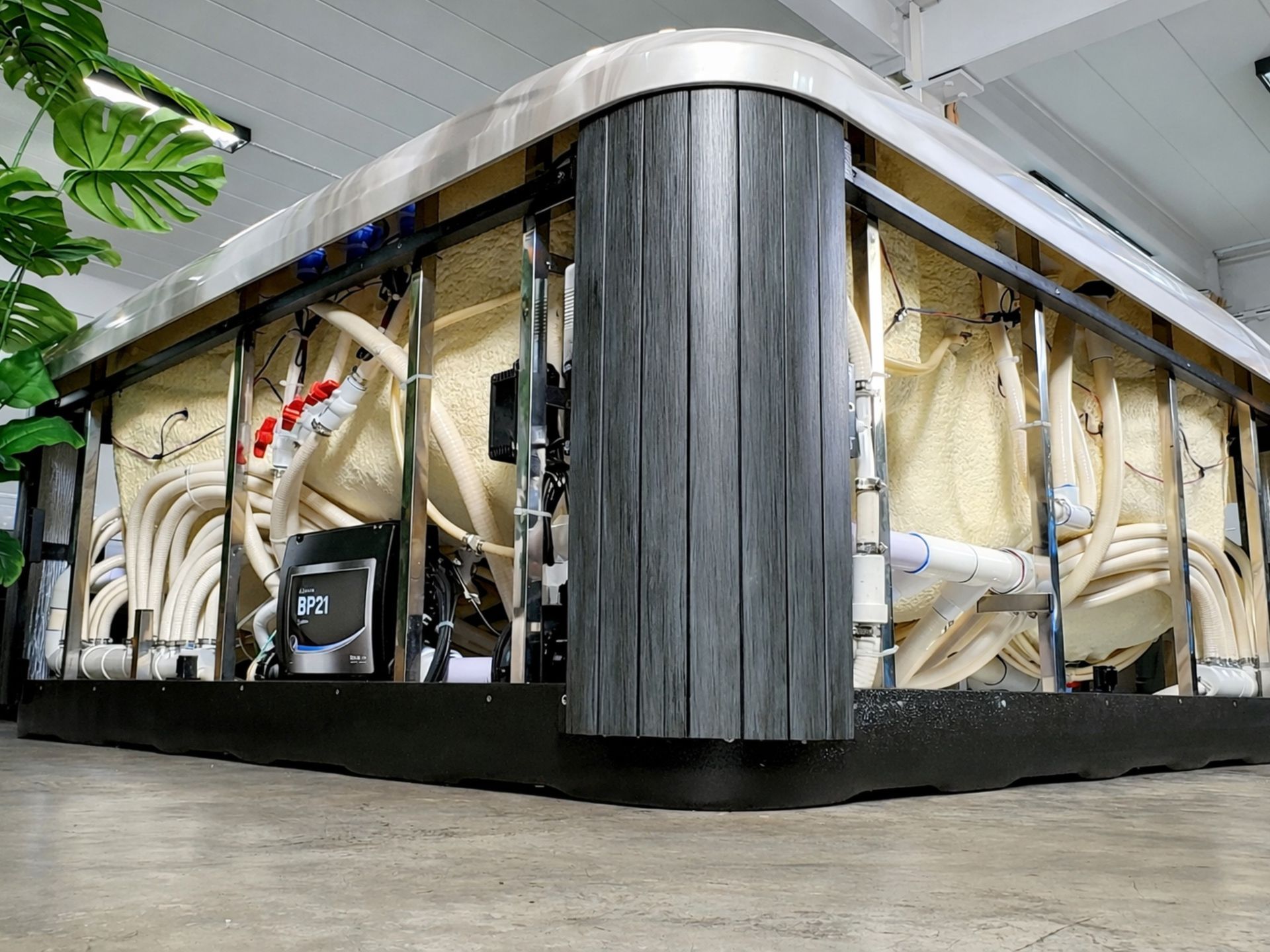Interior structure of hot tub showing plumbing system, PU foam insulation and spa control pack within reinforced steel frame