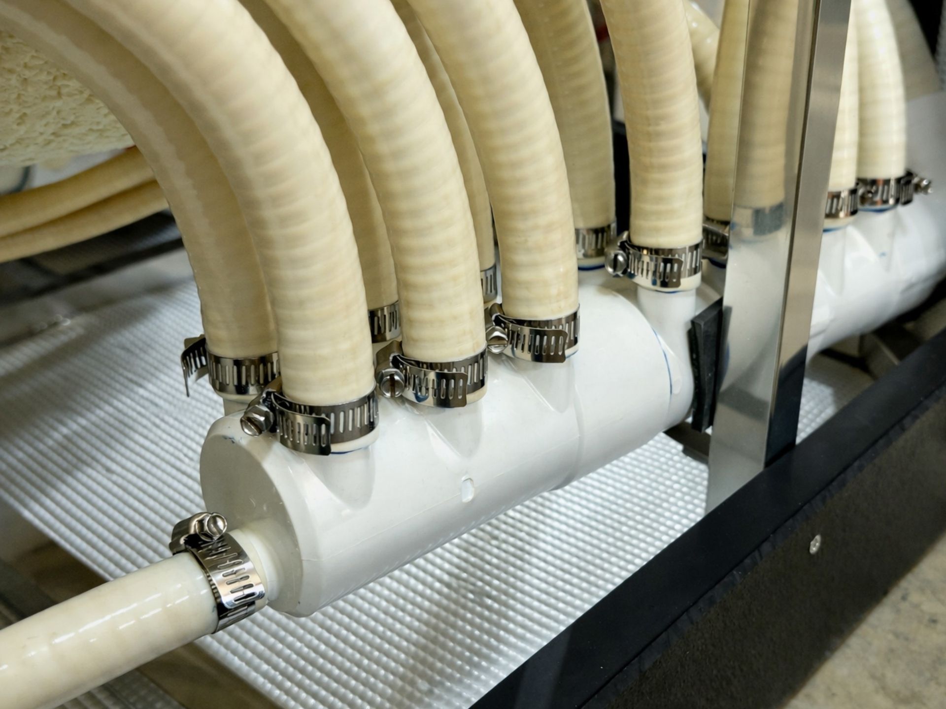Hot tub plumbing manifold system distributing water evenly to multiple hydrotherapy jets with reinforced hose clamps
