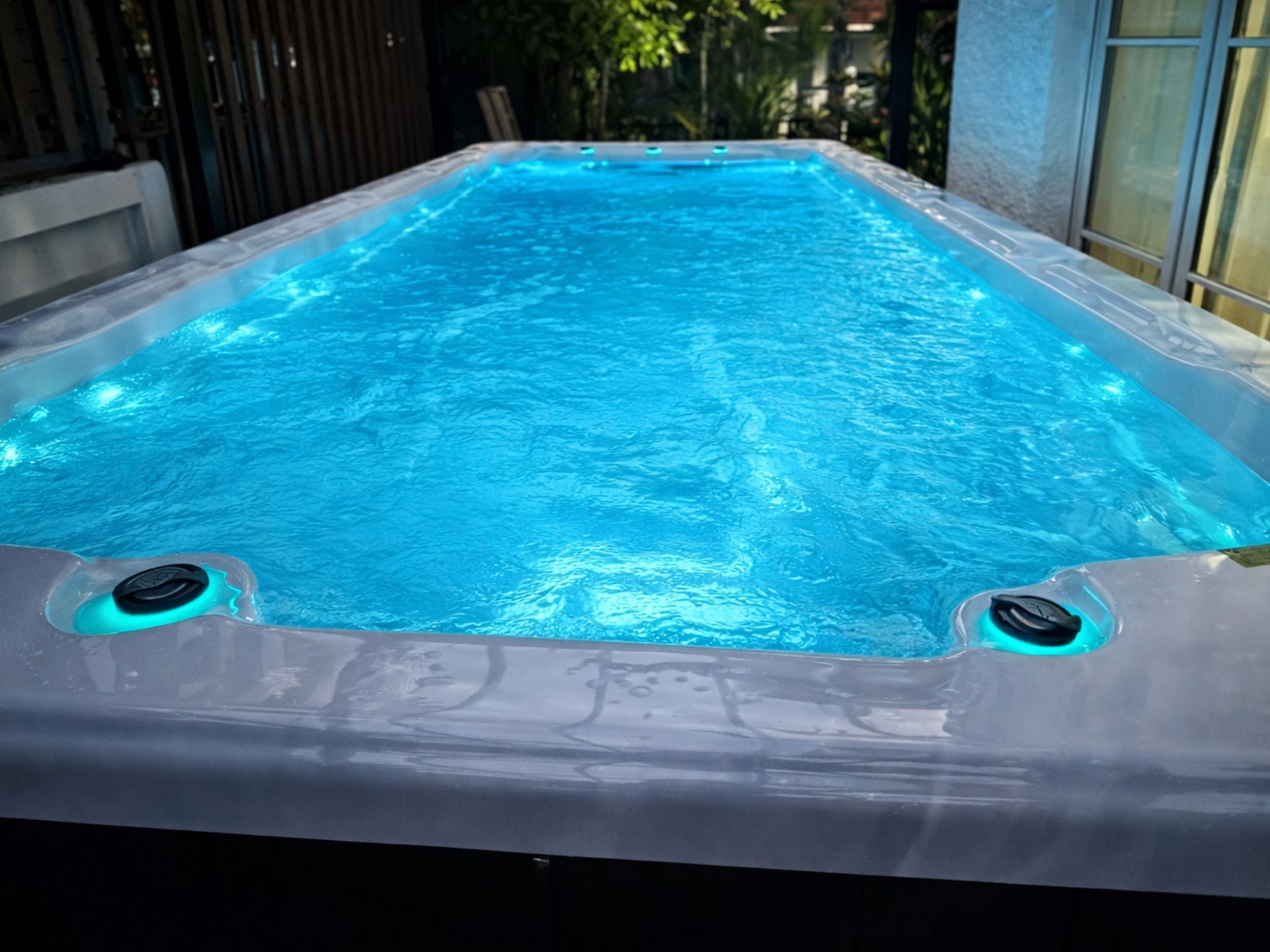 สระว่ายน้ำสปาติดตั้งกลางแจ้ง น้ำใสสีฟ้า พร้อมระบบไฟ LED ใต้น้ำ สร้างบรรยากาศผ่อนคลาย เหมาะสำหรับว่ายน้ำ ออกกำลังกาย และพักผ่อนภายในบ้าน