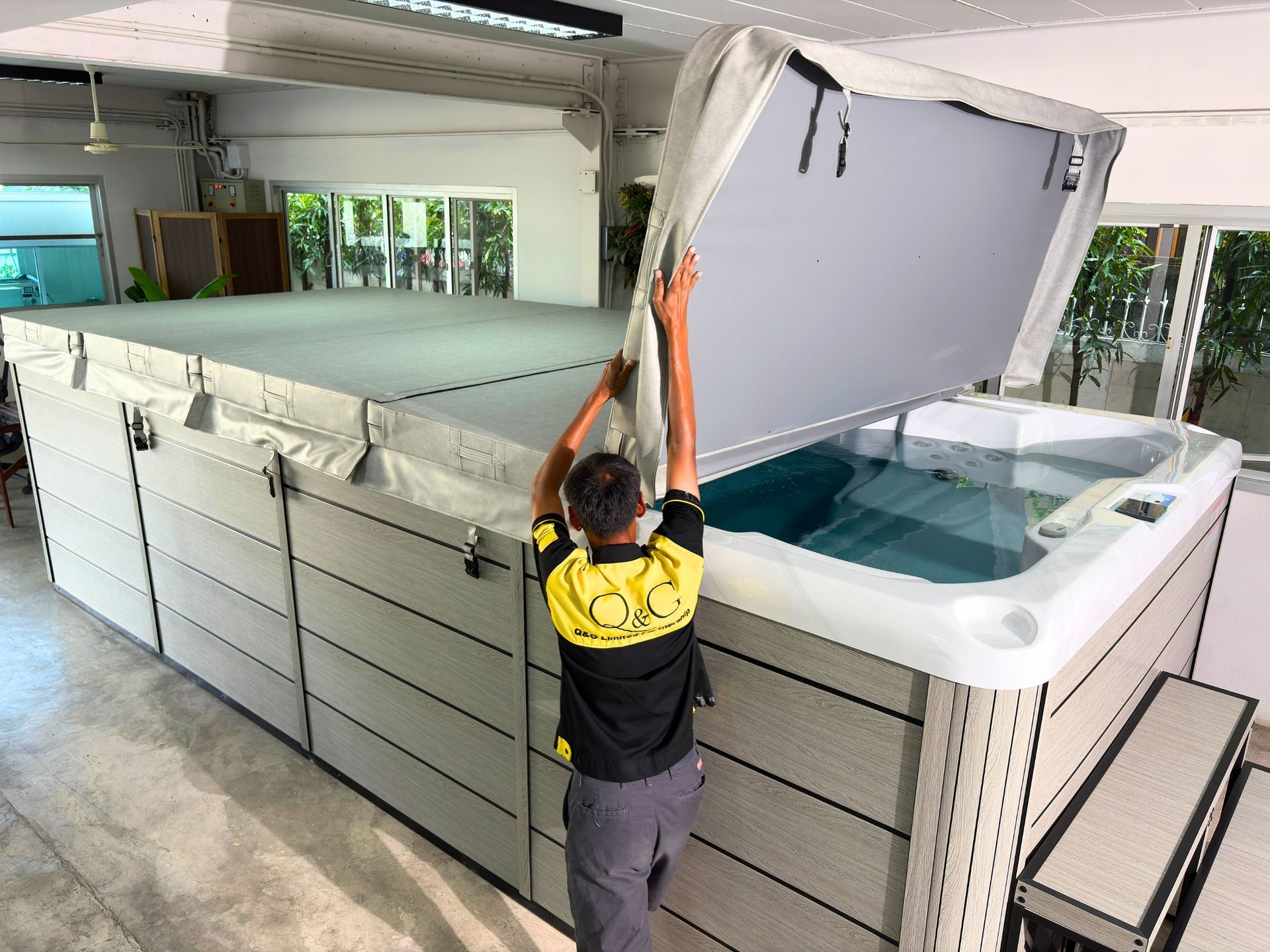 Swim spa insulated cover being lifted to reveal the acrylic interior, highlighting easy access and strong galvanized steel structure.